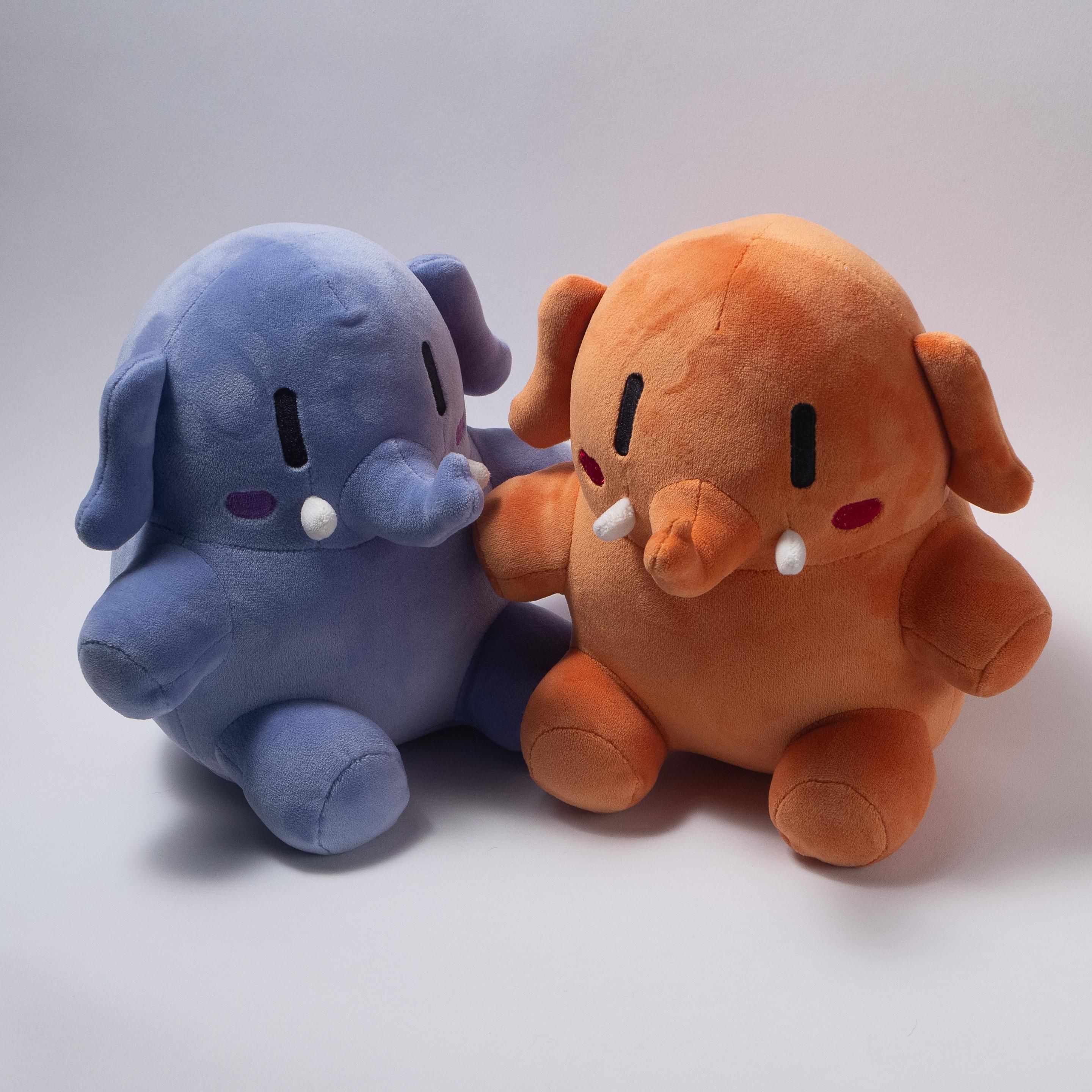 A blue and apricot colored stuffed Mastodon toys sitting next to each other on ambiguous white background.