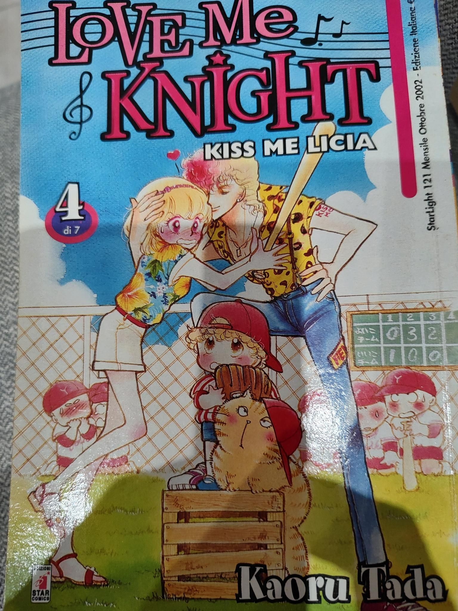 grossomodo la copertina del quarto volume di Ai shite knight (Kiss me licia). Il particolare di un campo da baseball con dei ragazzini in divisa imbarazzati sullo sfondo e, in primo piano, Go (Mirko) che bacia una riluttante Yakko (Licia "fettine panate") mentre vengono osservati da Hashizo (questo nome originale mi fa sempre pisciare sotto dal ridere, Andrea) e Giuliano