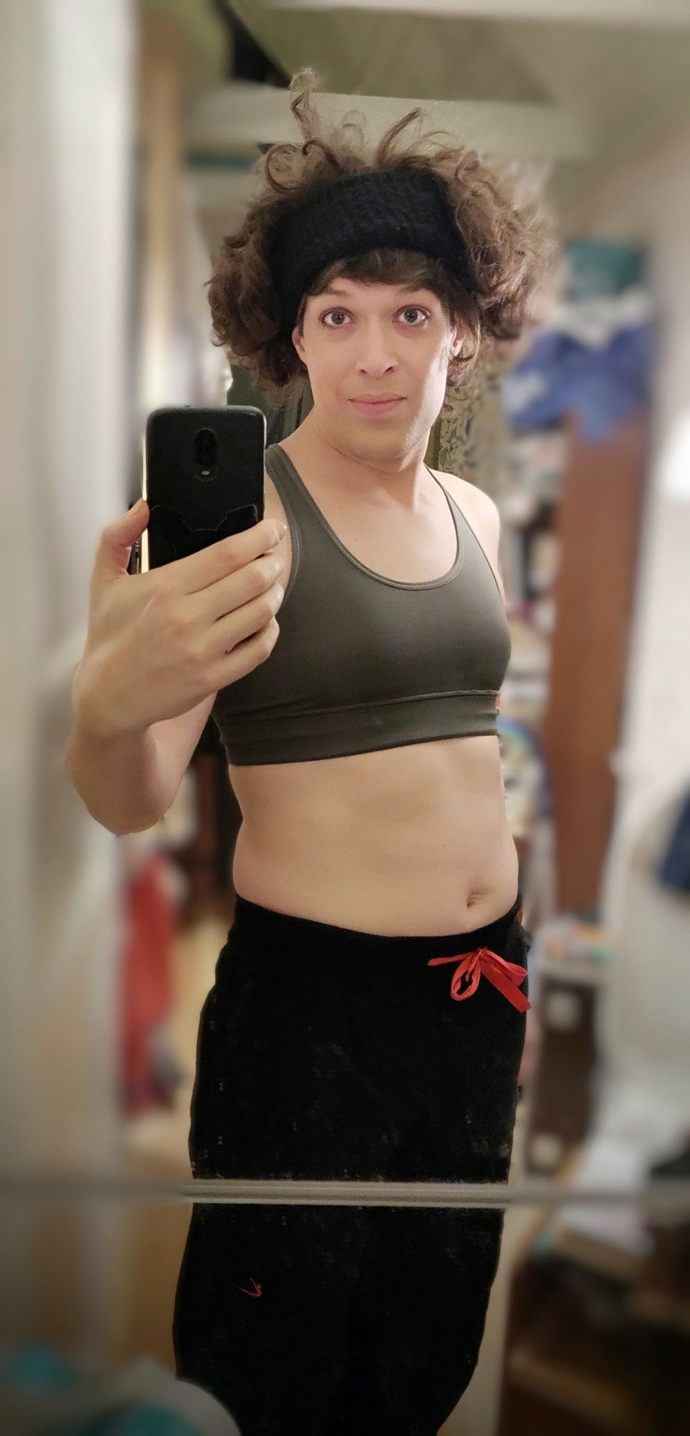 me in black exercise pants and a compression bra, and a thick black sweat band on my head making my hair stand on end and looking silly