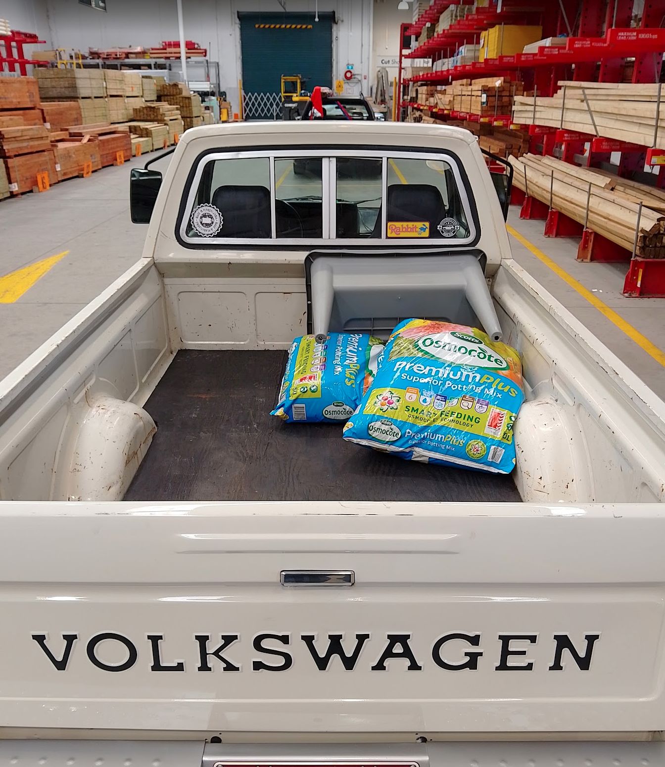 Roger the white VW Rabbit pickup at Bunnings with a load of potting mix and planter on board