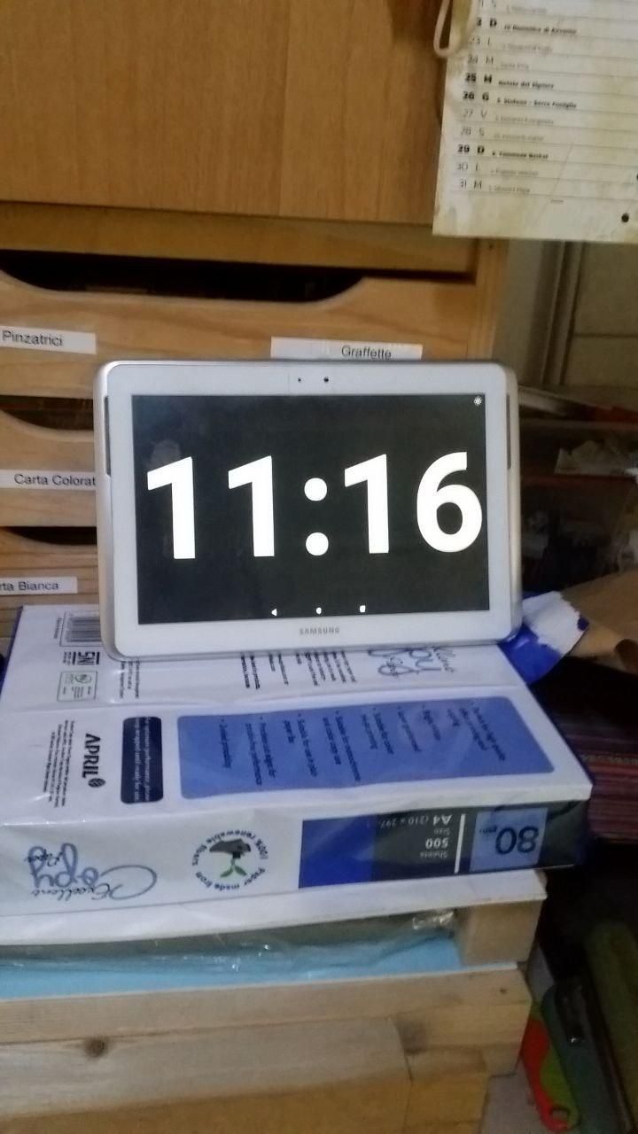 Tablet che mostra l'ora (11:16) a tutto schermo, con numeri bianchi su sfondo nero.