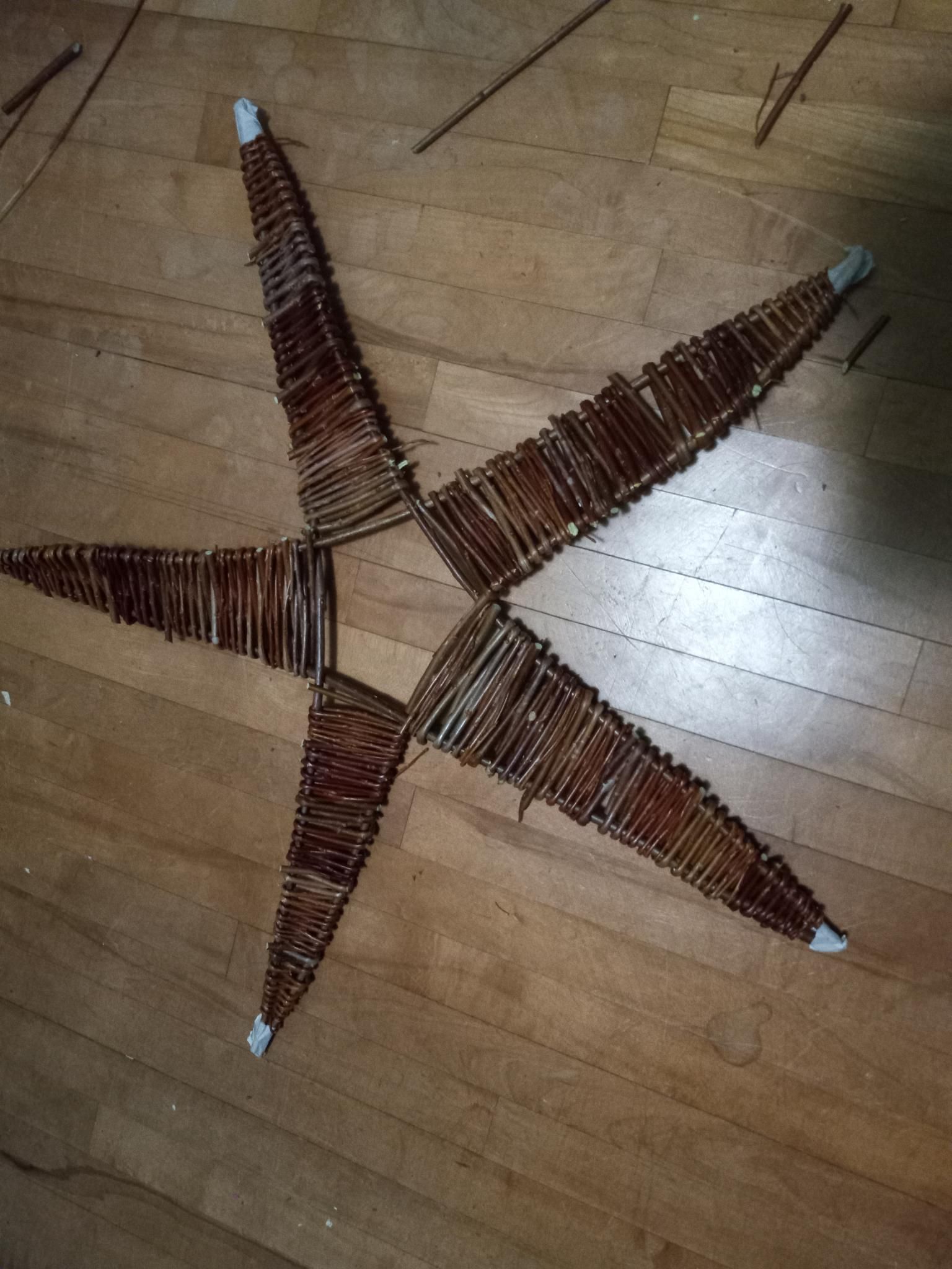 Looking down onto a hardwood floor with a woven willow 5 pointed star