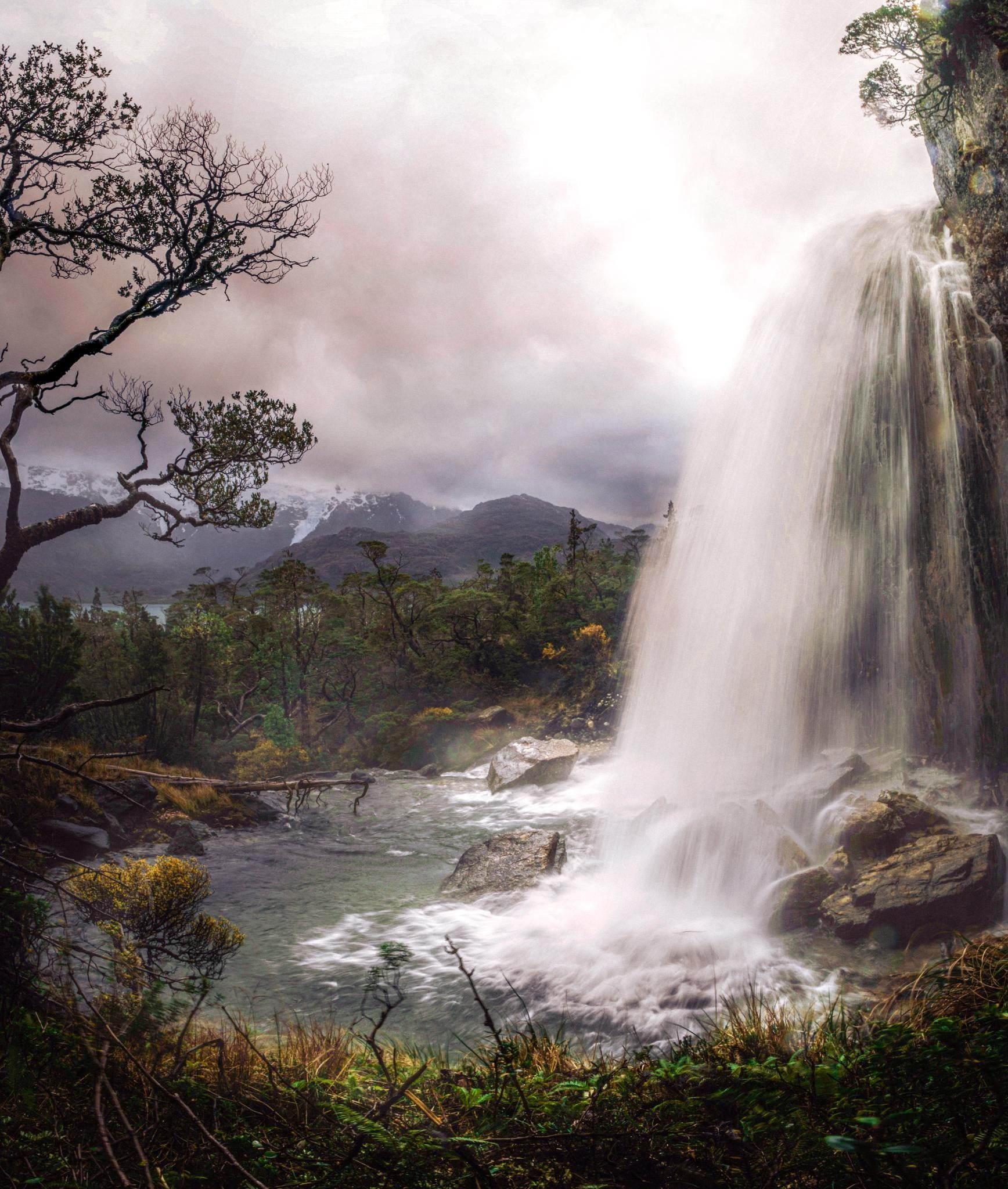 image is of a waterfall in Patagonia with glaciers in the background
