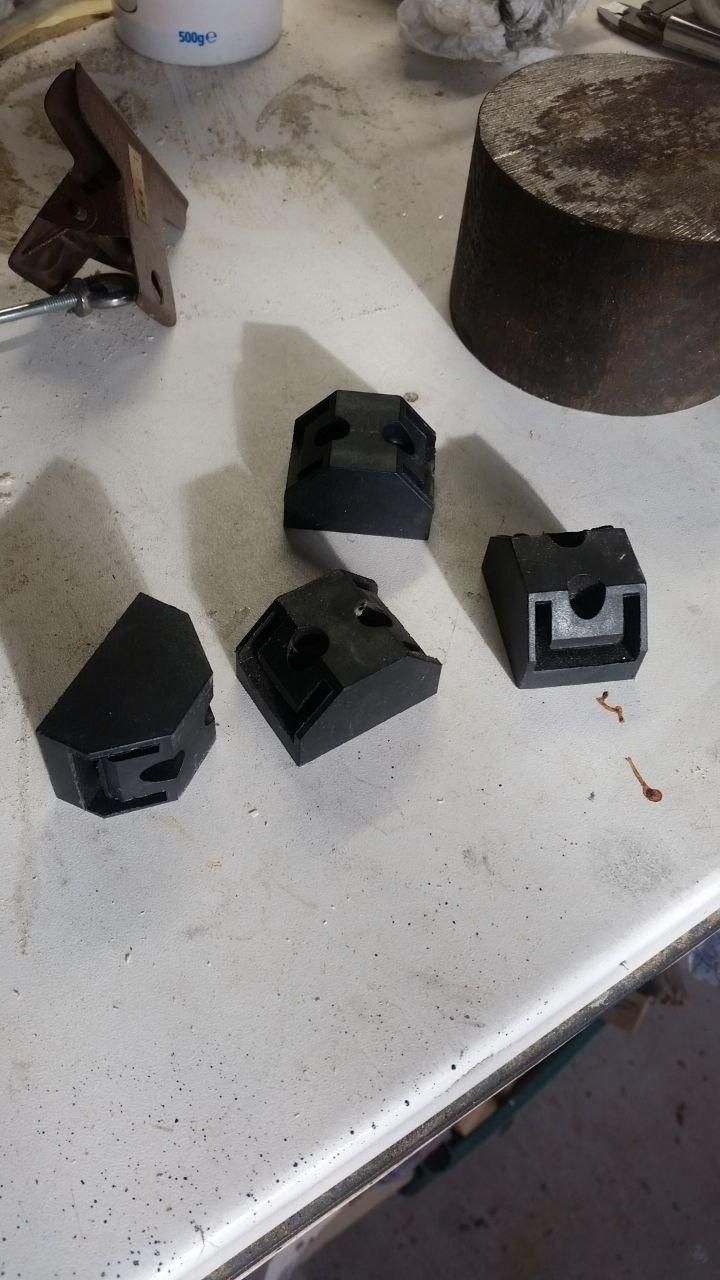 Quattro terminali in plastica nera per barre calamitate a U, con fori svasati per due viti di fissaggio.