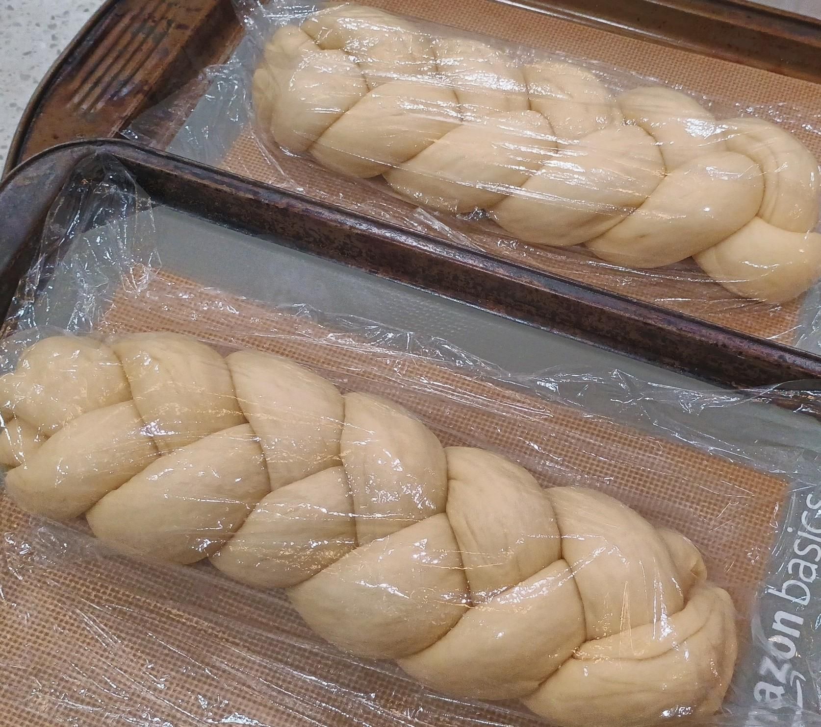 Two braided loaves sit waiting for the oven. 
