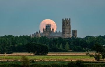 a brilliant picture of a bright, salmon pink moon rising behind Ely cathedral. 

The pictures show a sequence of shots where the moon gradually travels behind the cathedral towers and spires.