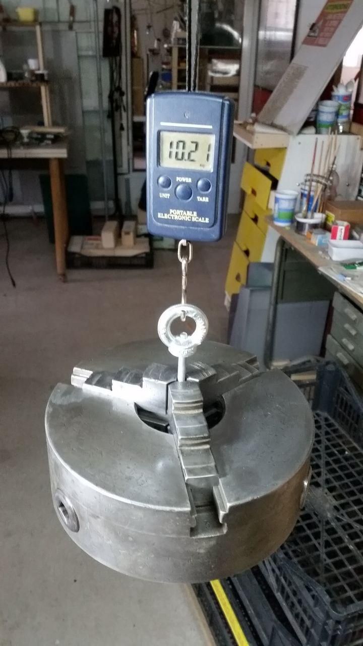 Il mandrino da 200 mm appeso alla bilancia, che segna 10.21 kg.