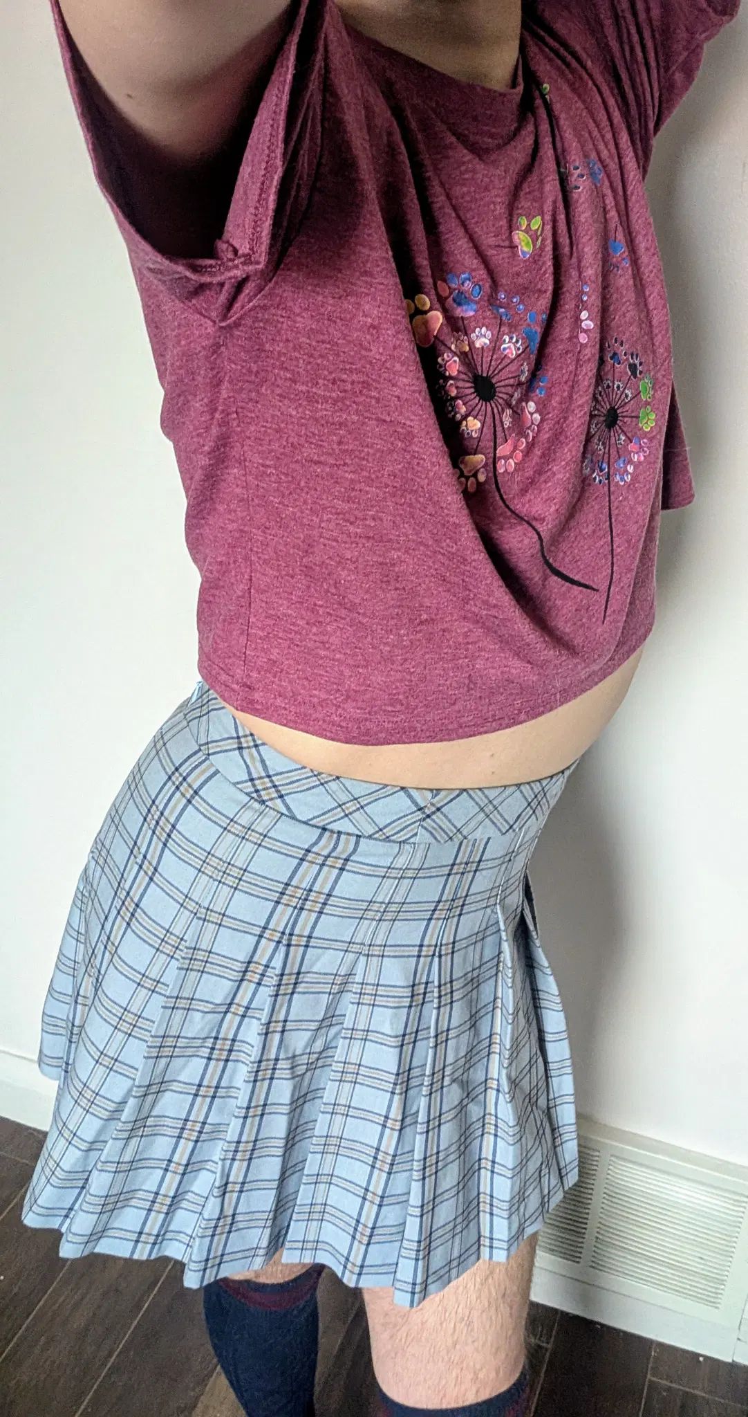 I stretch my arms in the air to show my smooth tummy. My ass, wrapped in  blue plaid pleated skirt, sticks out slightly to show my body off.
I am wearing knee high socks and a reddish, loose, cropped t-shirt.