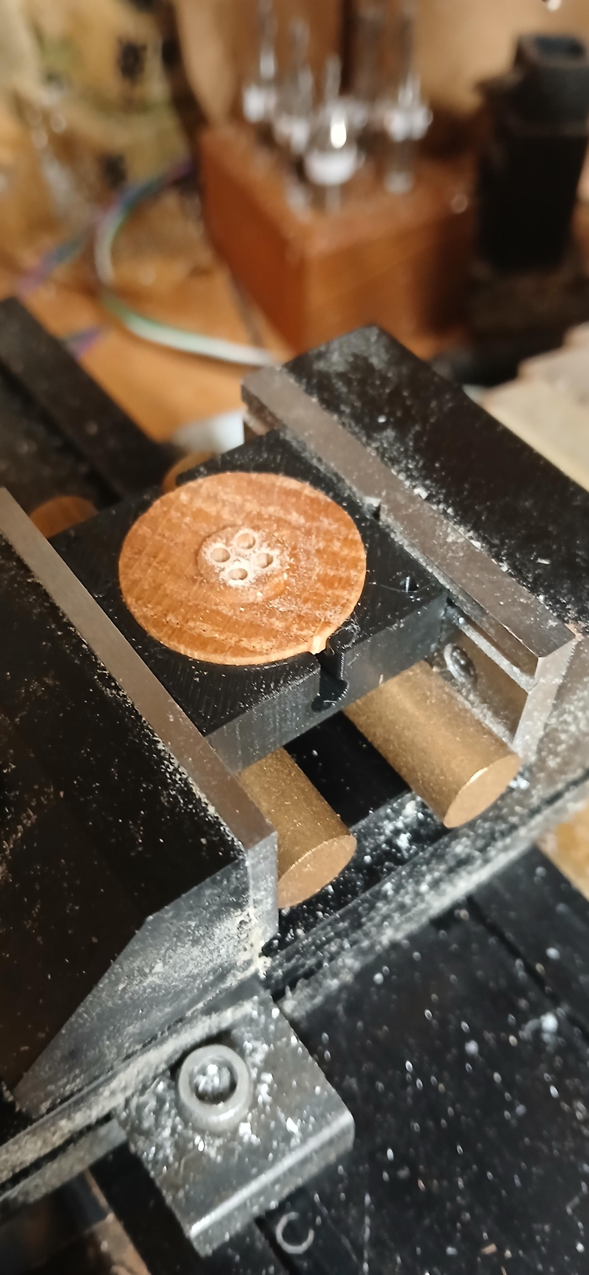 Oak button in black pla jig in black work vise on the CNC mill