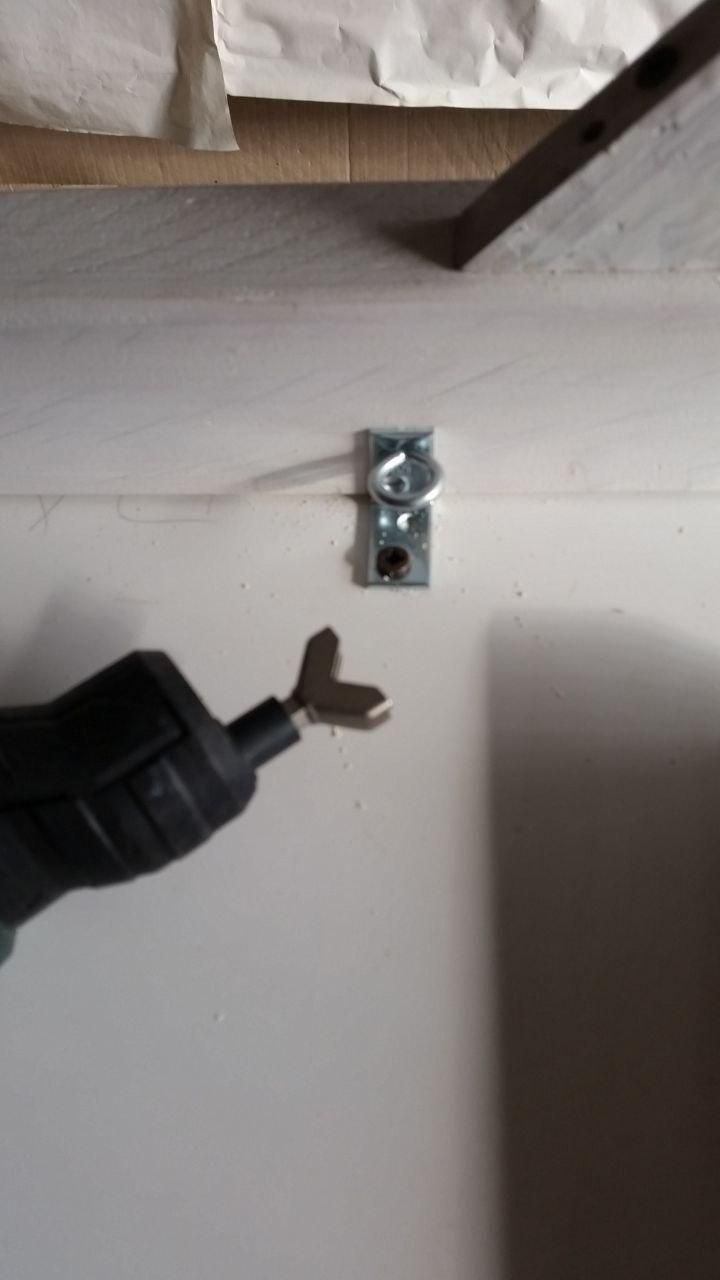 Staffa a L fissata con una vite Pozi nel piano (capovolto) e con una vite a occhiello sul supporto laterale.
Sull'avvitatore è montata la punta per girare le viti a occhiello.