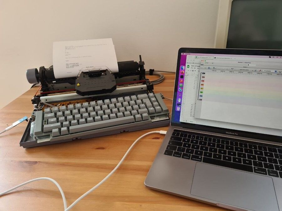 An electric typewriter connected to a laptop running a logic analyzer software