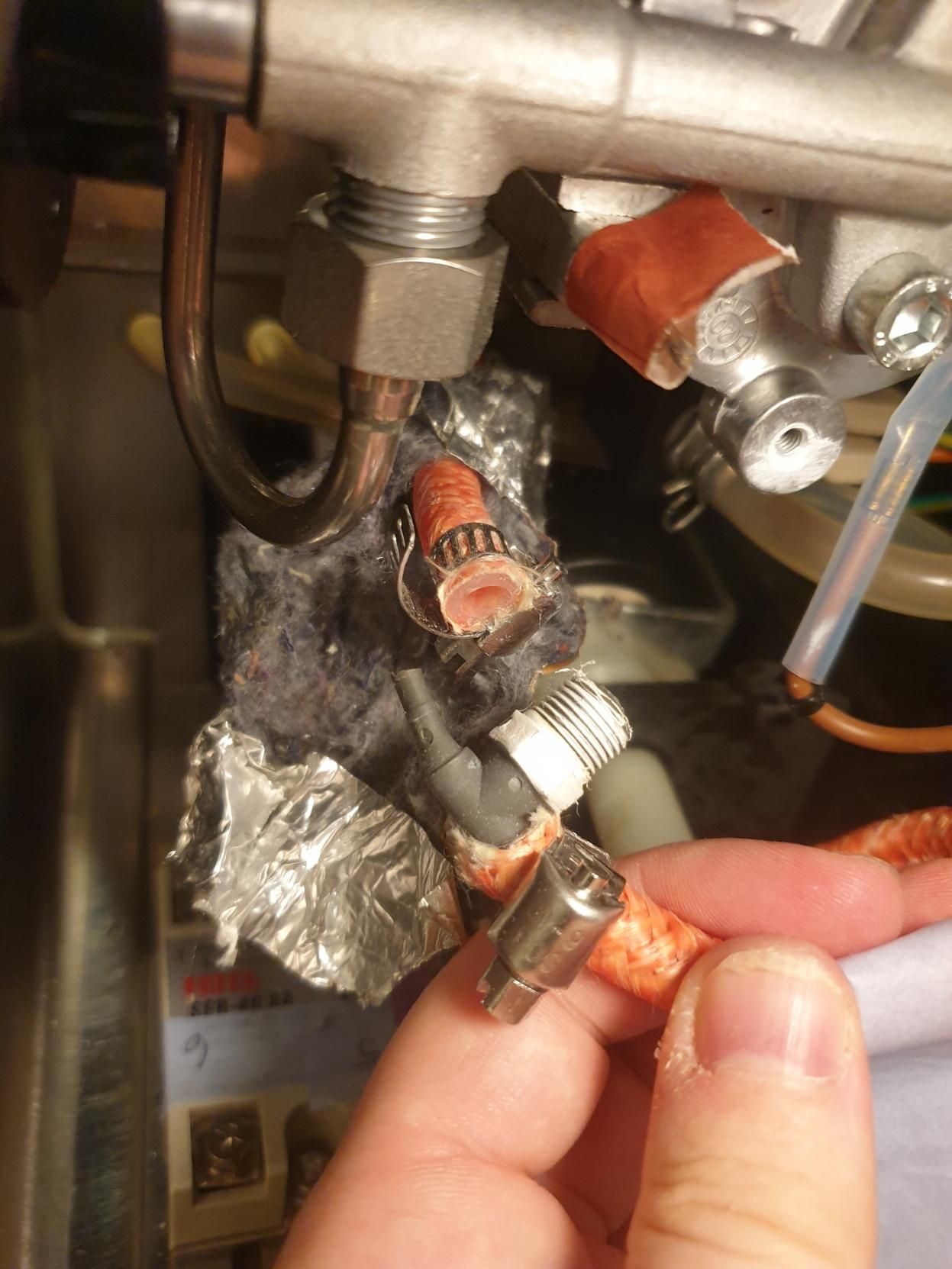 Part I don't know what to call, made of plastic and connecting two insulated silicone tubes to each other plus a male screw connection for a brass tube off at a right angle. They're disconnected but otherwise in their correct places inside an espresso machine.