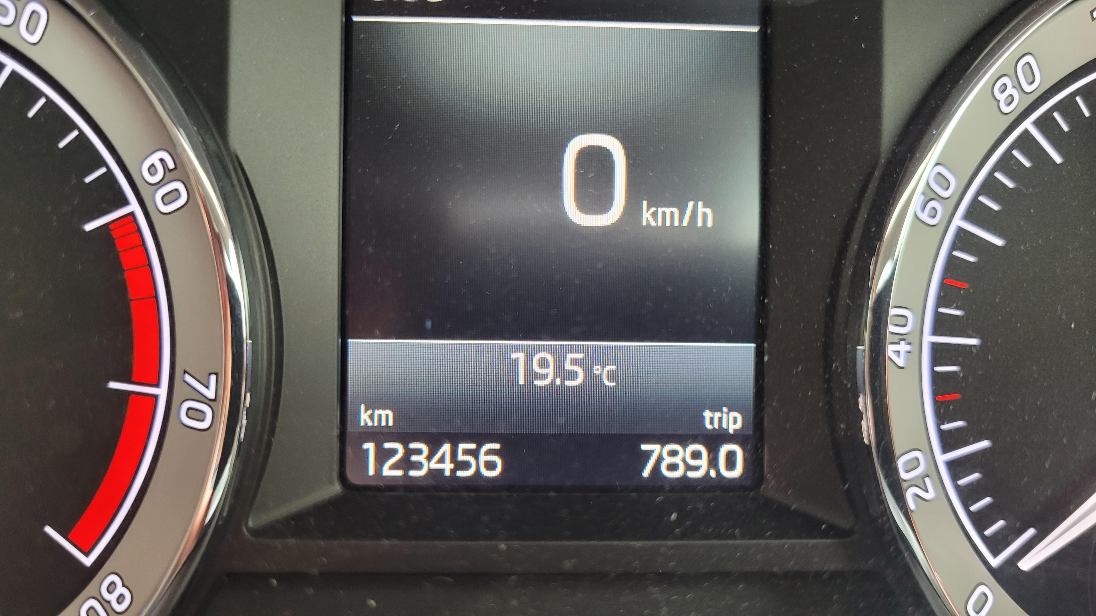 Close up photo of a cars gauge cluster, showing the odometer at one hundred and twenty three thousand, four hundred and fifty six kilometres, with a trip meter showing seven hundred and eighty nine, point zero. 
Consecutively, the numbers are 123,456 789.0.