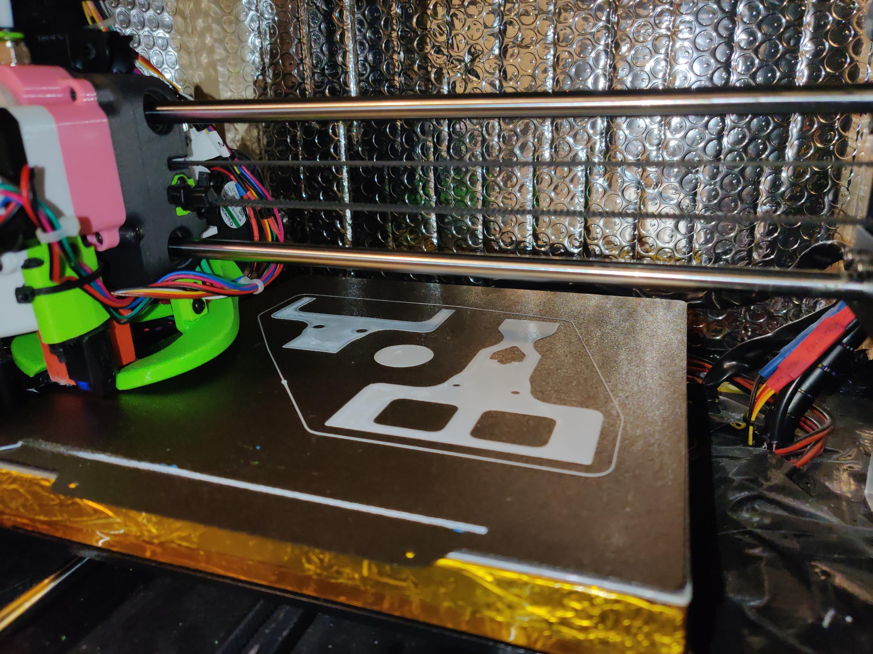 Photo of the inside of a 3D printer, there currently are three objects being printed.