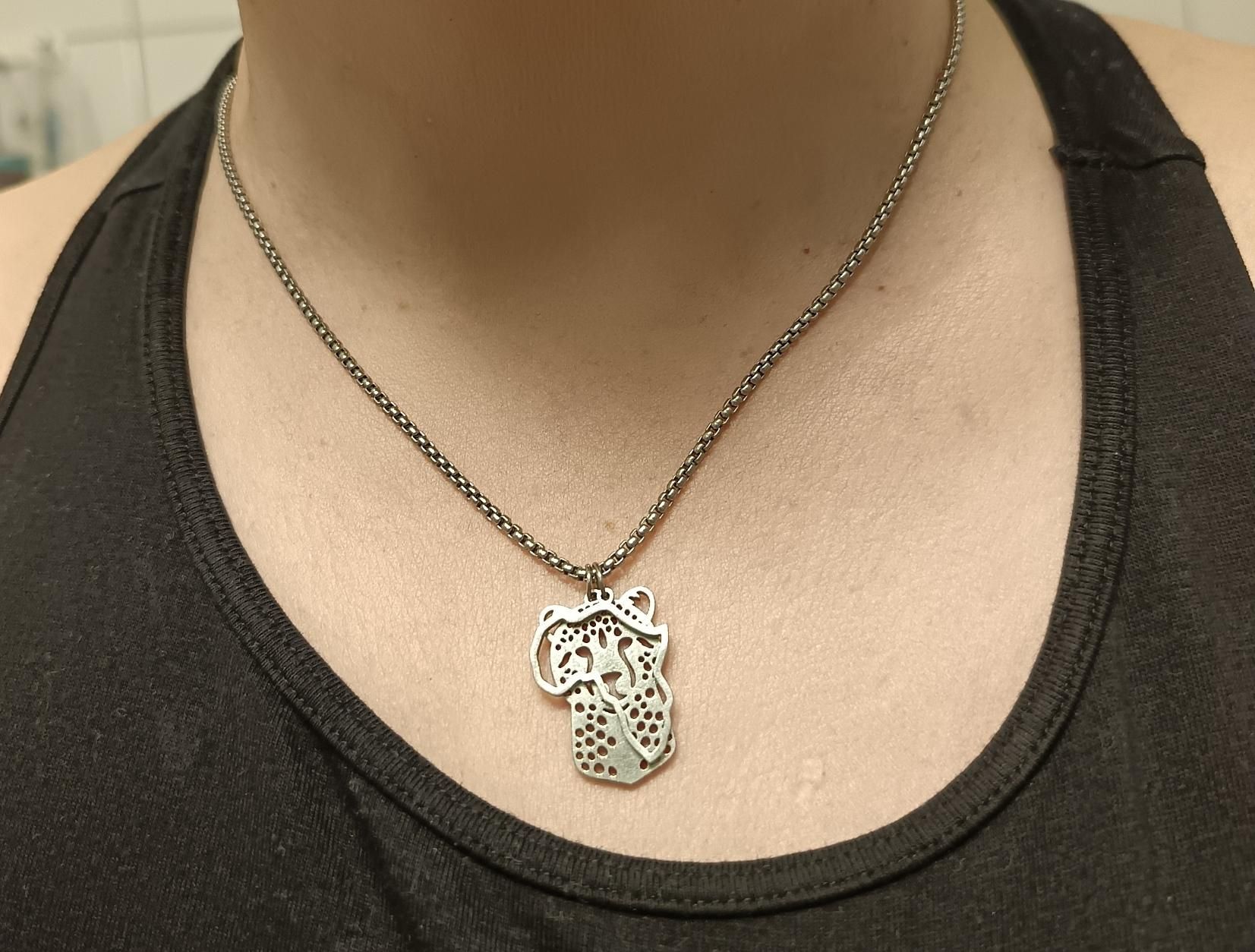 kaulassa koru, jossa gepardi- ja afrikkariipukset.