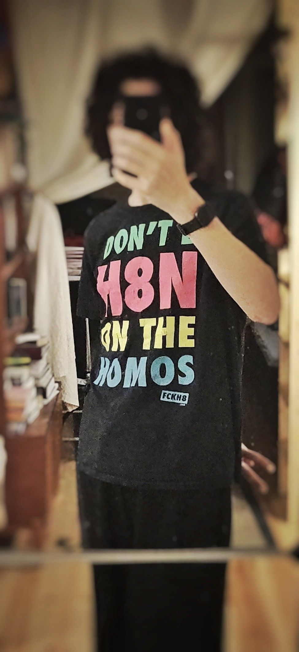 Selfie with head obscured, wearing a t-shirt that says "don't be hating on the homos" in several colours. There's a veeery slight hint of a figure on it.
