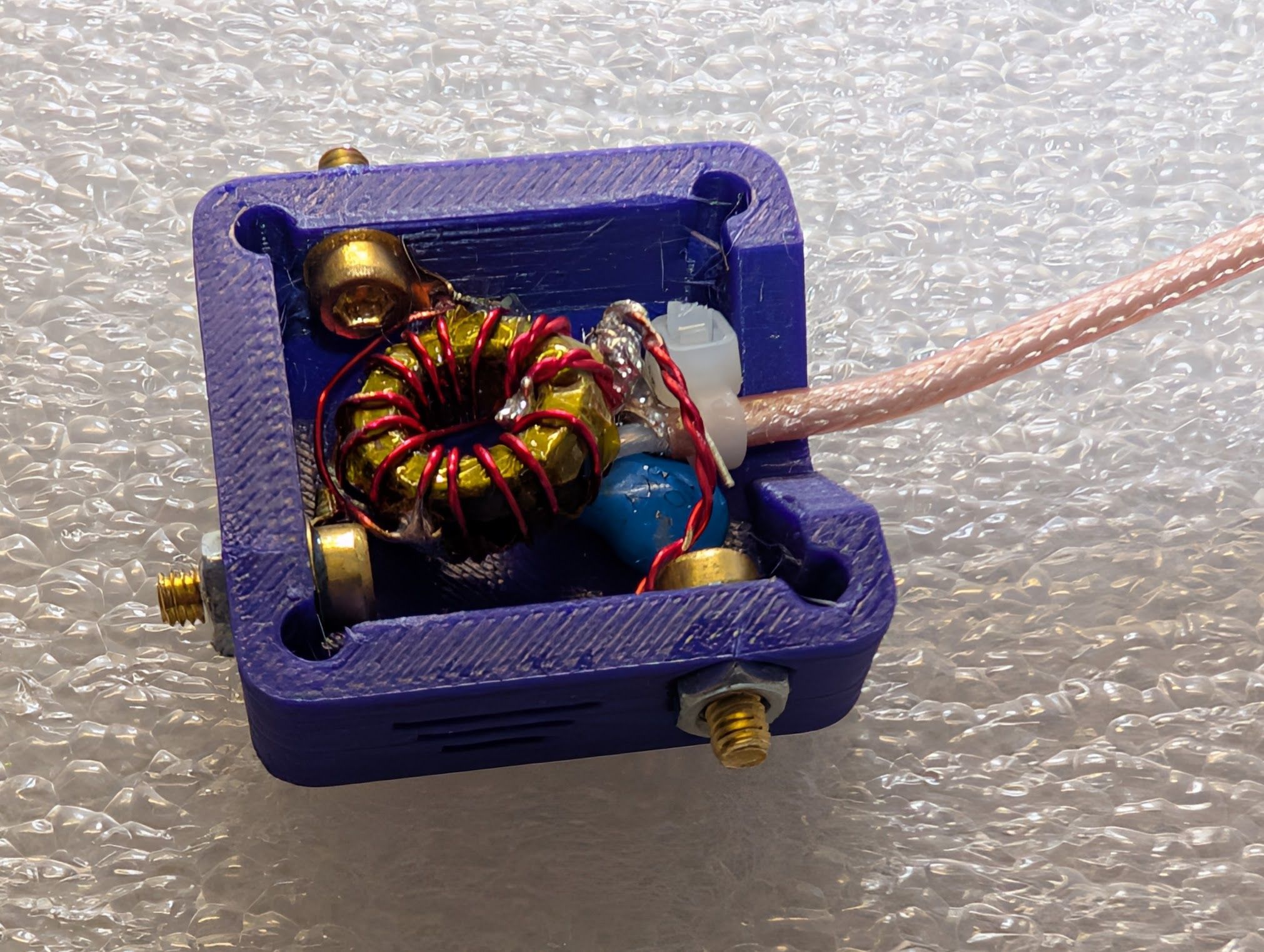 The parts installed in the box, with all three screws in place and tightened into captive nuts, and a small cable tie installed for strain relief.