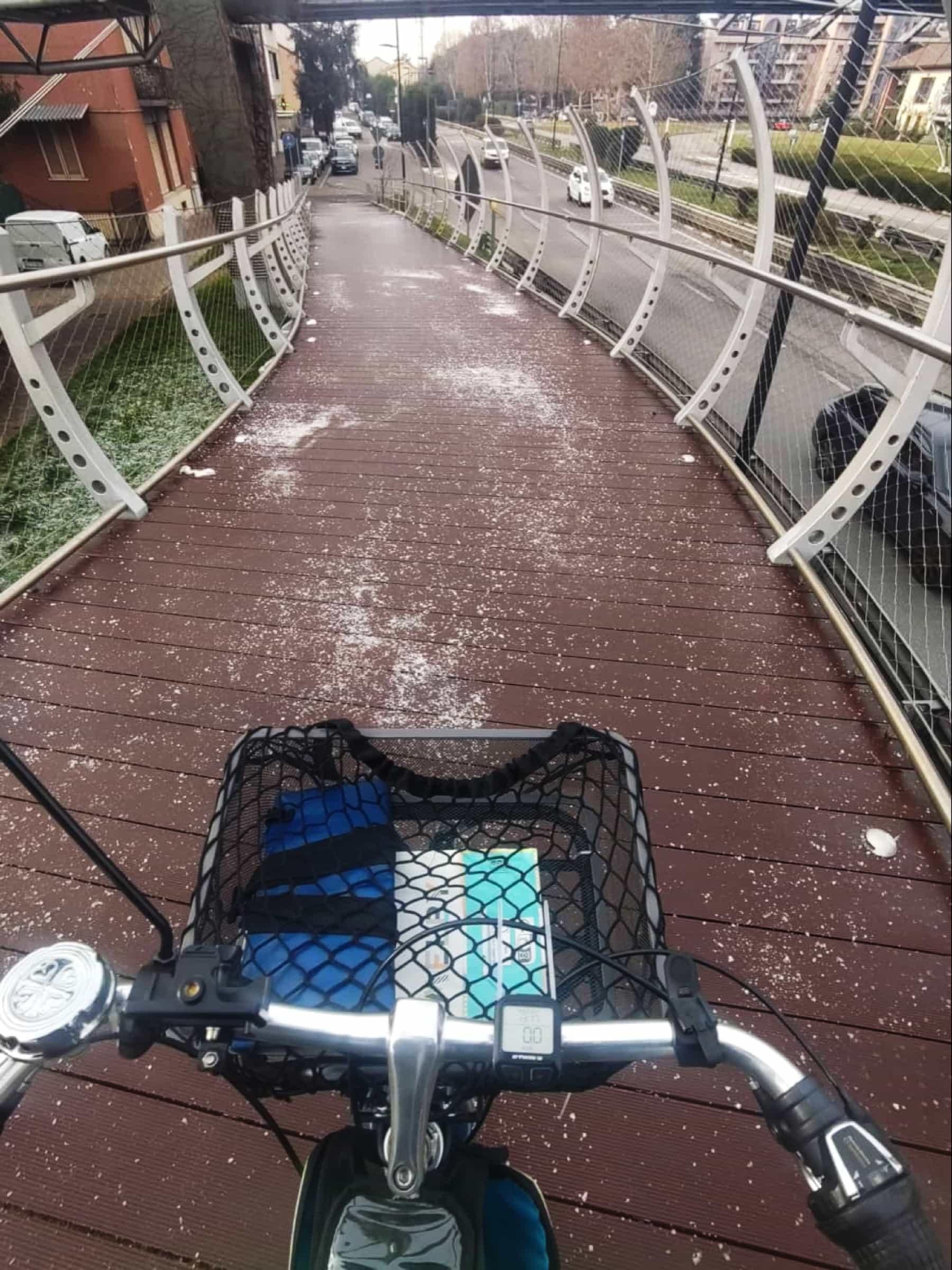 🇮🇹 Foto dal manubrio della mia bici. Si vede una pedana di "legno sintetico" in discesa su cui è presente moltissimo sale sparso per contrastare il ghiaccio

🇬🇧 Photo from my bike handlebar. You can see a platform of "synthetic wood" downhill on which there is a lot of salt scattered to counteract the ice