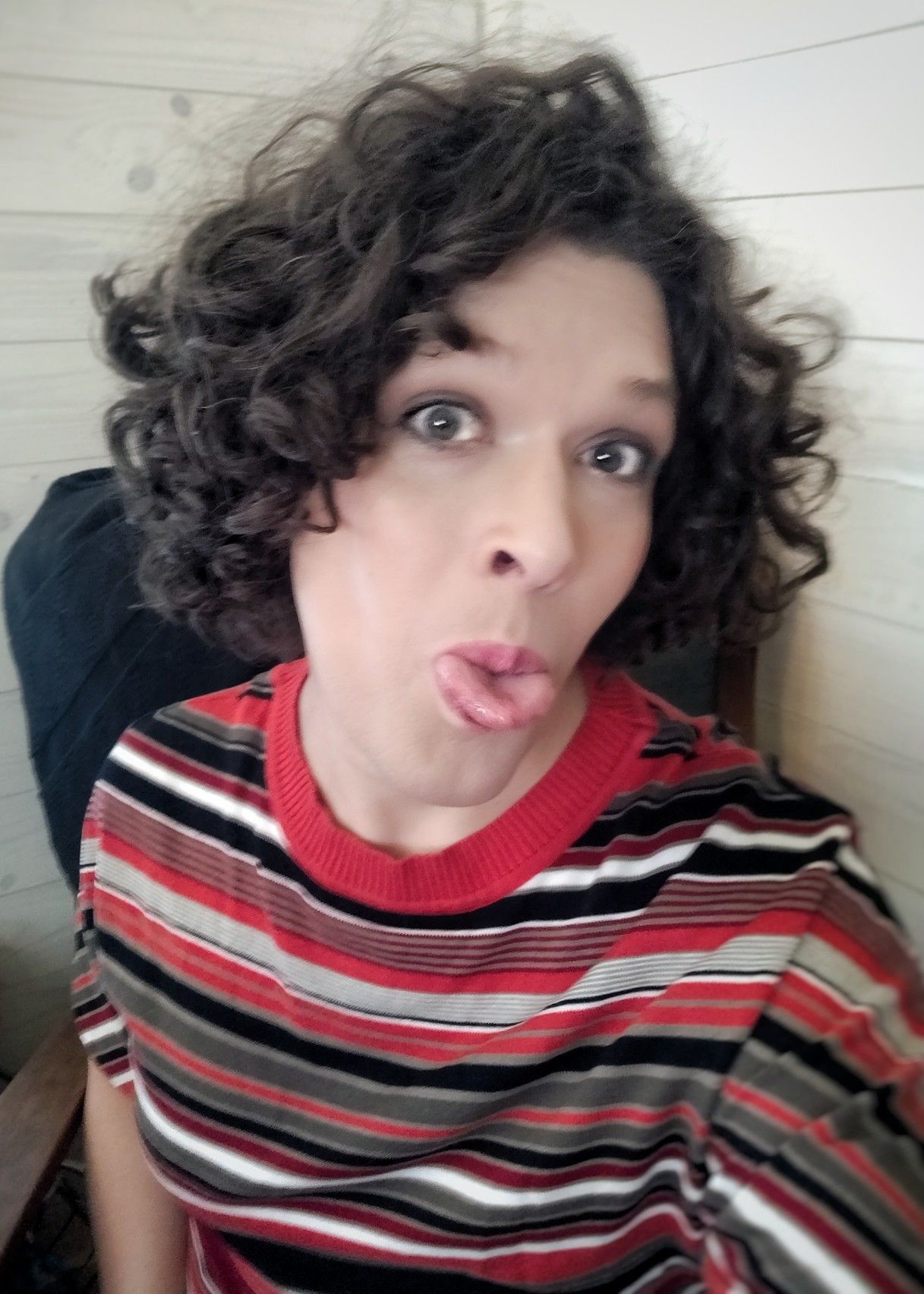 me in a red, black, white and grey top, sticking my tongue out at you