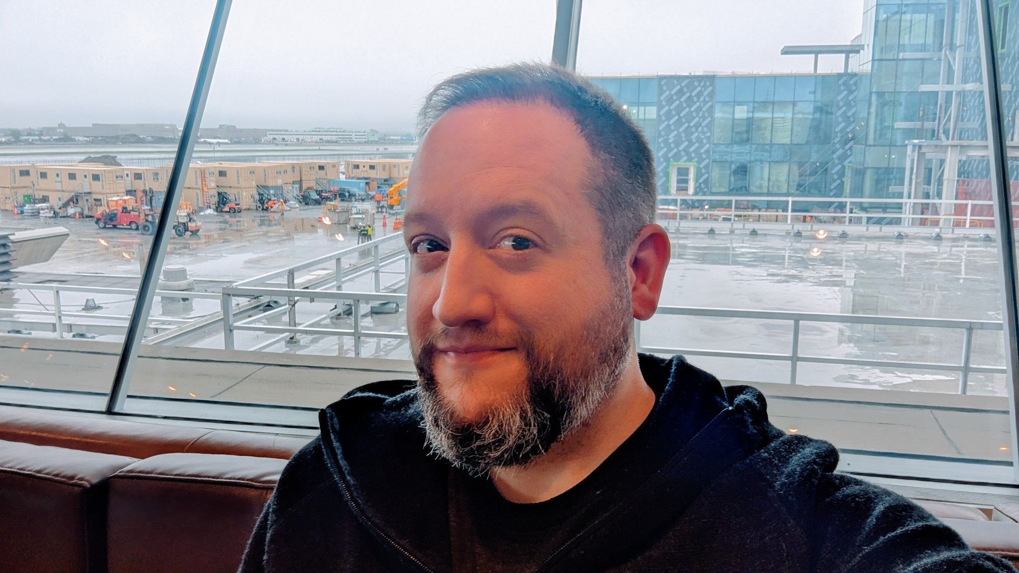 Selfie of me very close to my happy place: seated in a comfy chair, minutes away from boarding a plane to whisk me... somewhere.