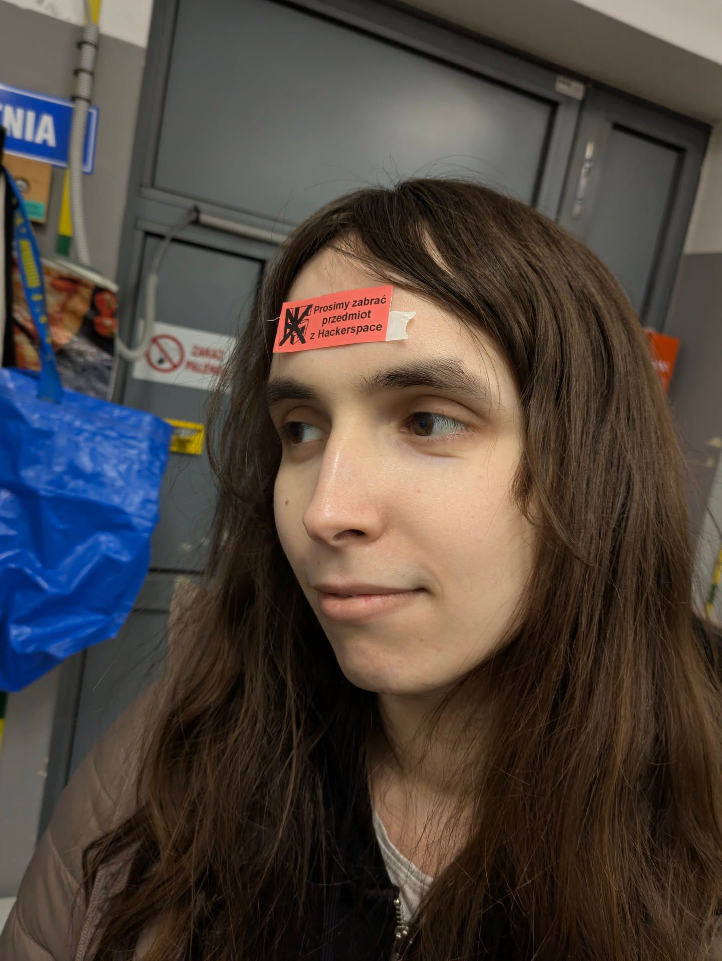 nicole with the "prosimy zabrać przedmiot z Hackerspace" (please remove [this] item from the Hackerspace) sticker on her forehead