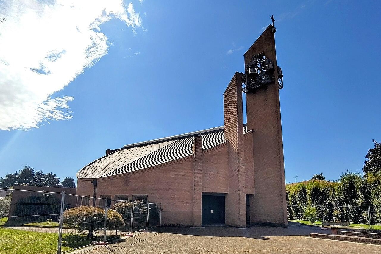 Foto Segrate chiesa della Beata Vergine Immacolata: un edificio a pianta circolare in mattoni con tetto spiovente  e campanile frontale
https://commons.wikimedia.org/wiki/File%3ASegrate_%28MI%29_-_frazione_Lavanderie_-_chiesa_della_Beata_Vergine_Immacolata.jpg