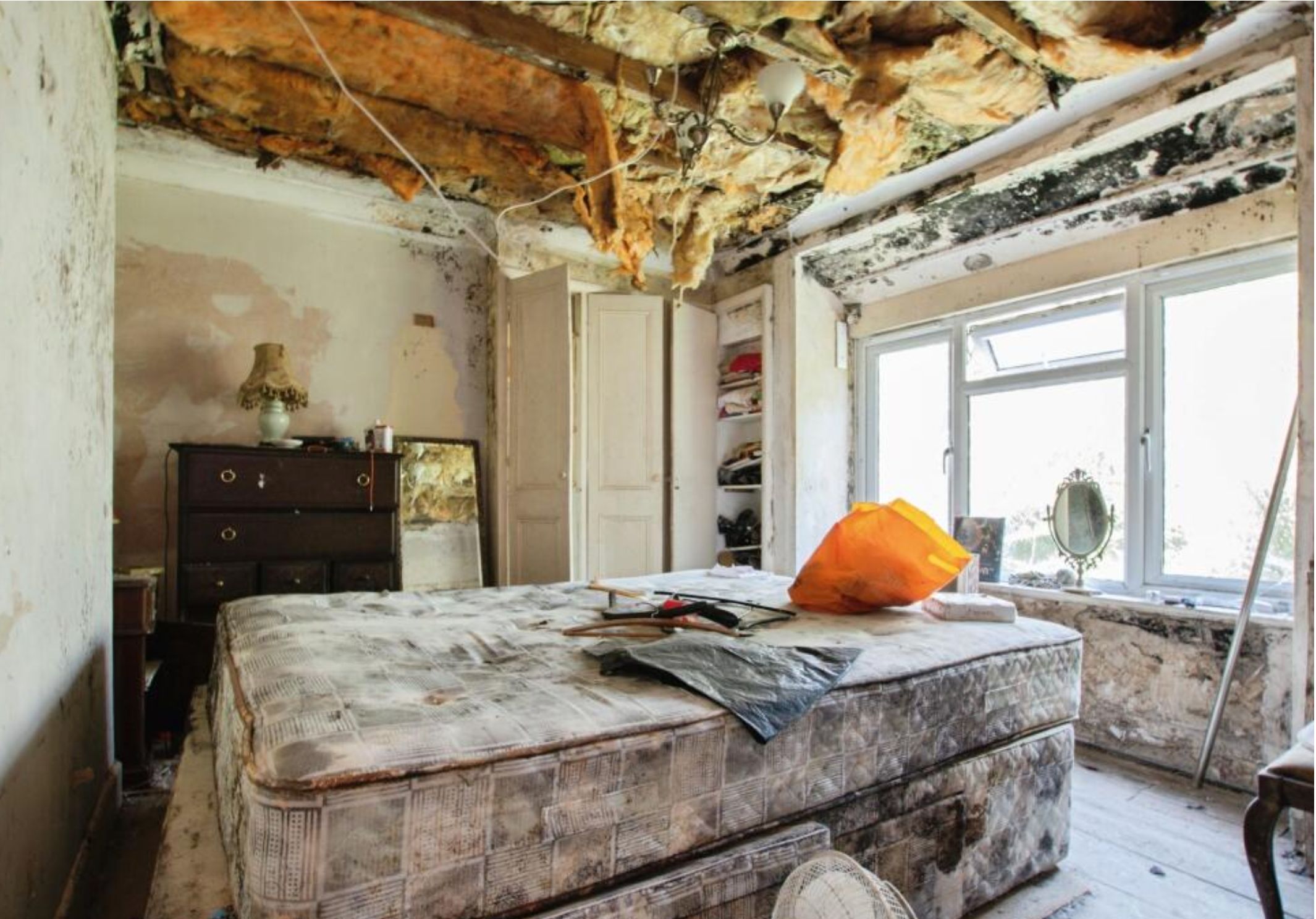 Another bedroom with mould on the walls and a mouldy mattress, with the ceiling caving in even worse. 