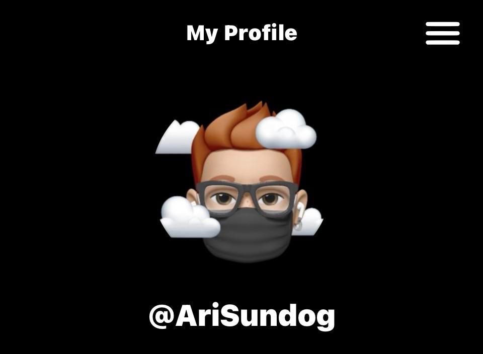 A screenshot of my Loops profile. On a black background it shows my cartoon head with short red hair and chunky glasses, wearing a black face mask, with little puffy clouds around the head (same as my icon on this account), and my username, @ AriSundog. 