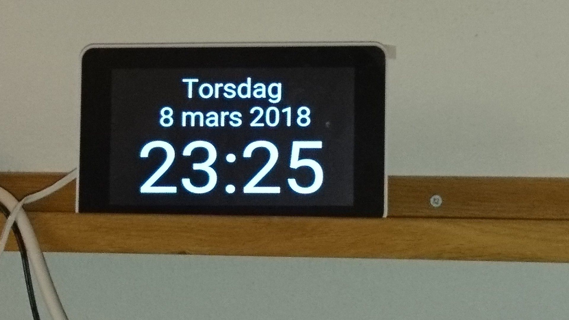 Digital clock display with words for the day of week and for the month.