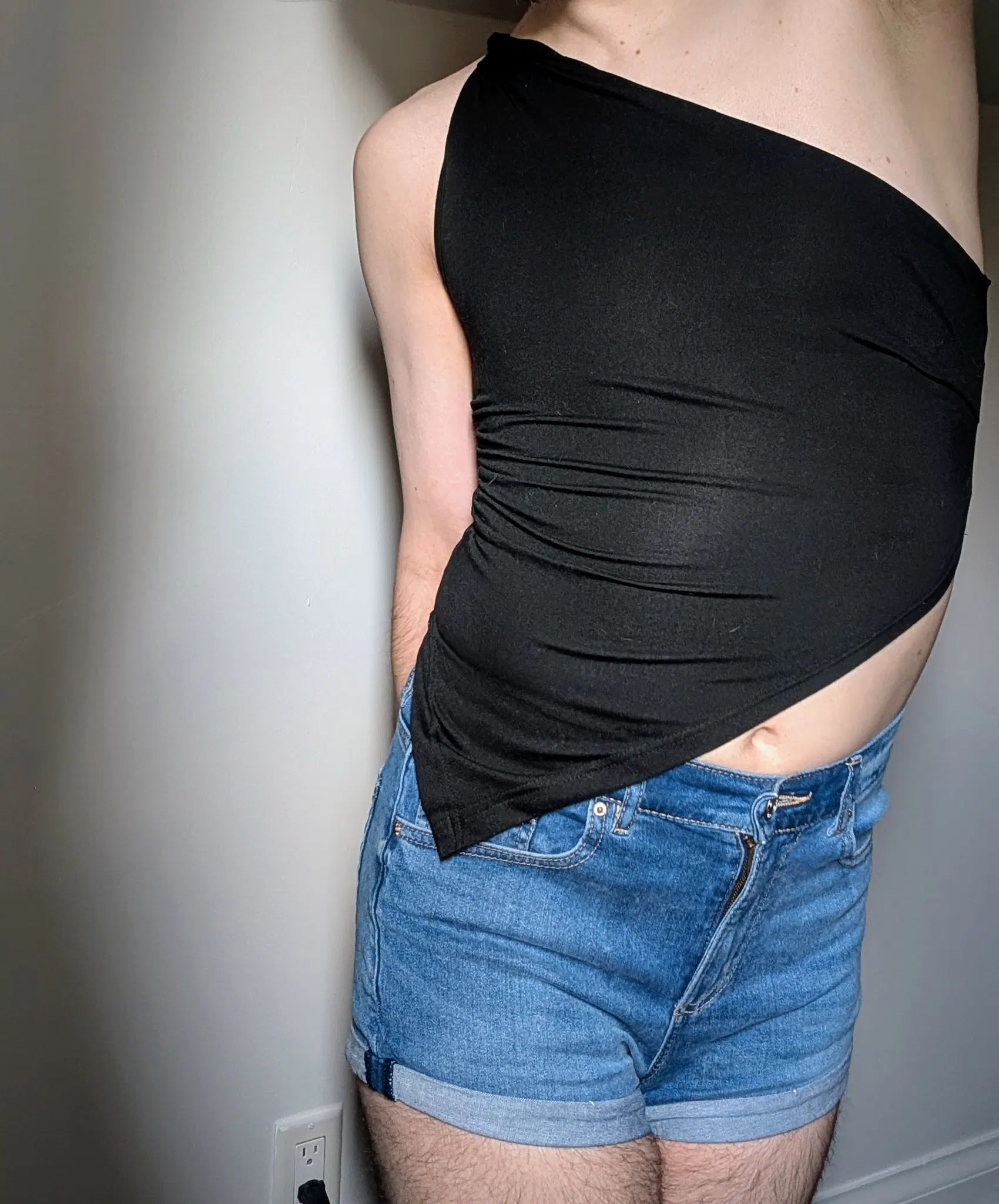 I stretch an arm straight up, stretching my body. My tight little jean shorts and fitted asymmetrical shirt show my shape and some skin. I love being seen and imagining your dirty thoughts 