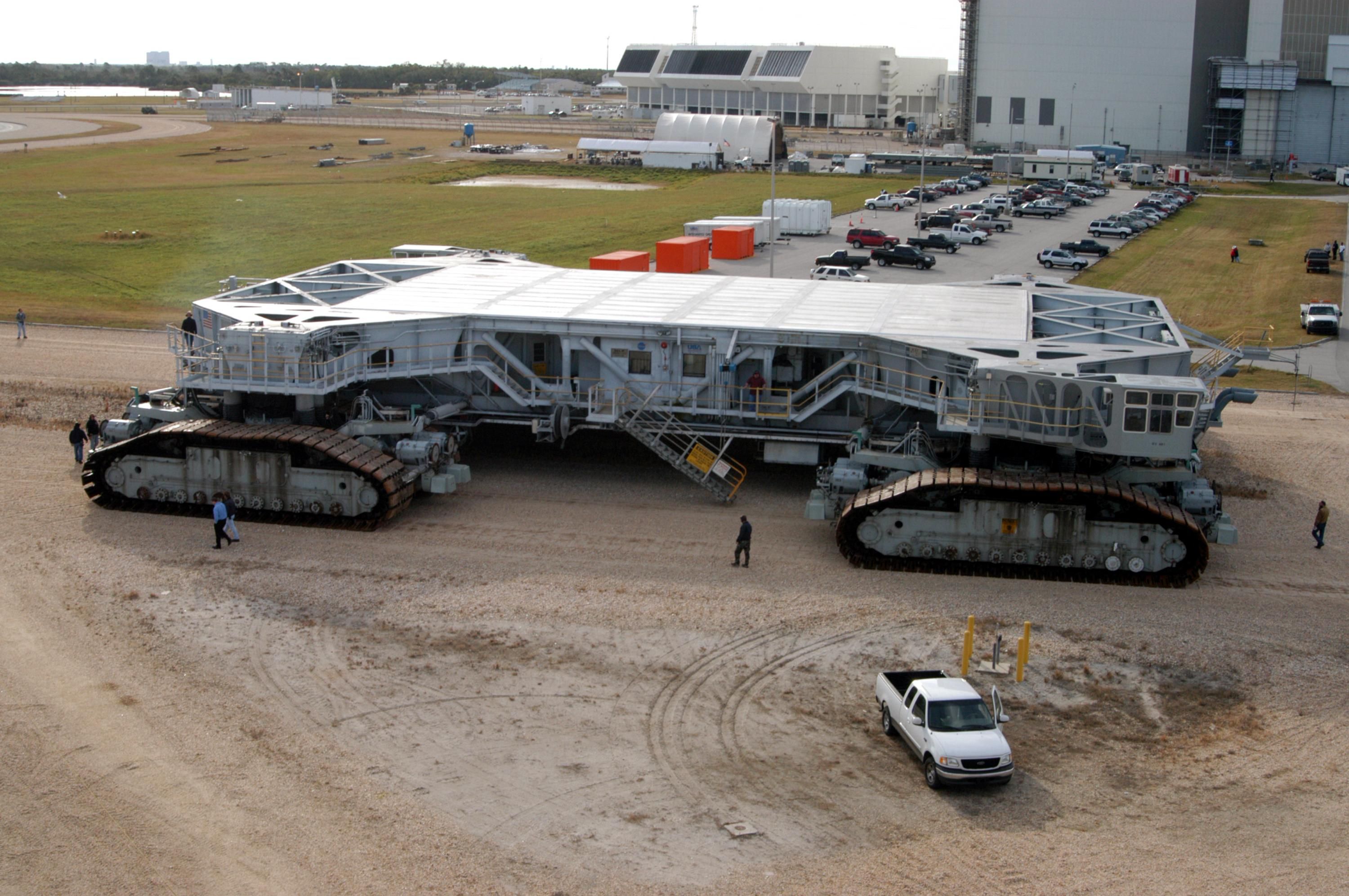 Crawler-transporter #2 beginning a road test on 21 December 2004 after replacement of the shoes on its caterpillar tracks. This replacement is part of the "Return to Flight" program, and Crawler #2 was used to transport Space Shuttle Discovery to the launch pad for the STS-114 mission. The Vehicle Assembly Building is just visible at upper right.