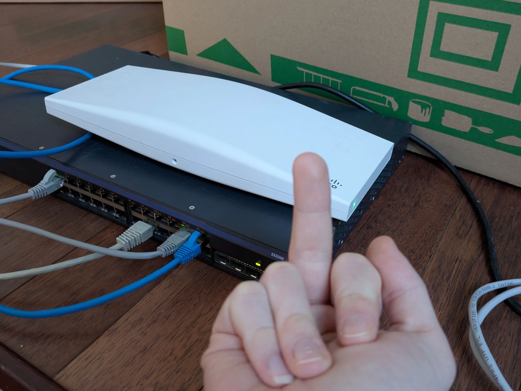 a juniper ex2200 and a meraki mr46 atop
...and my hand showing a middle finger at the AP
