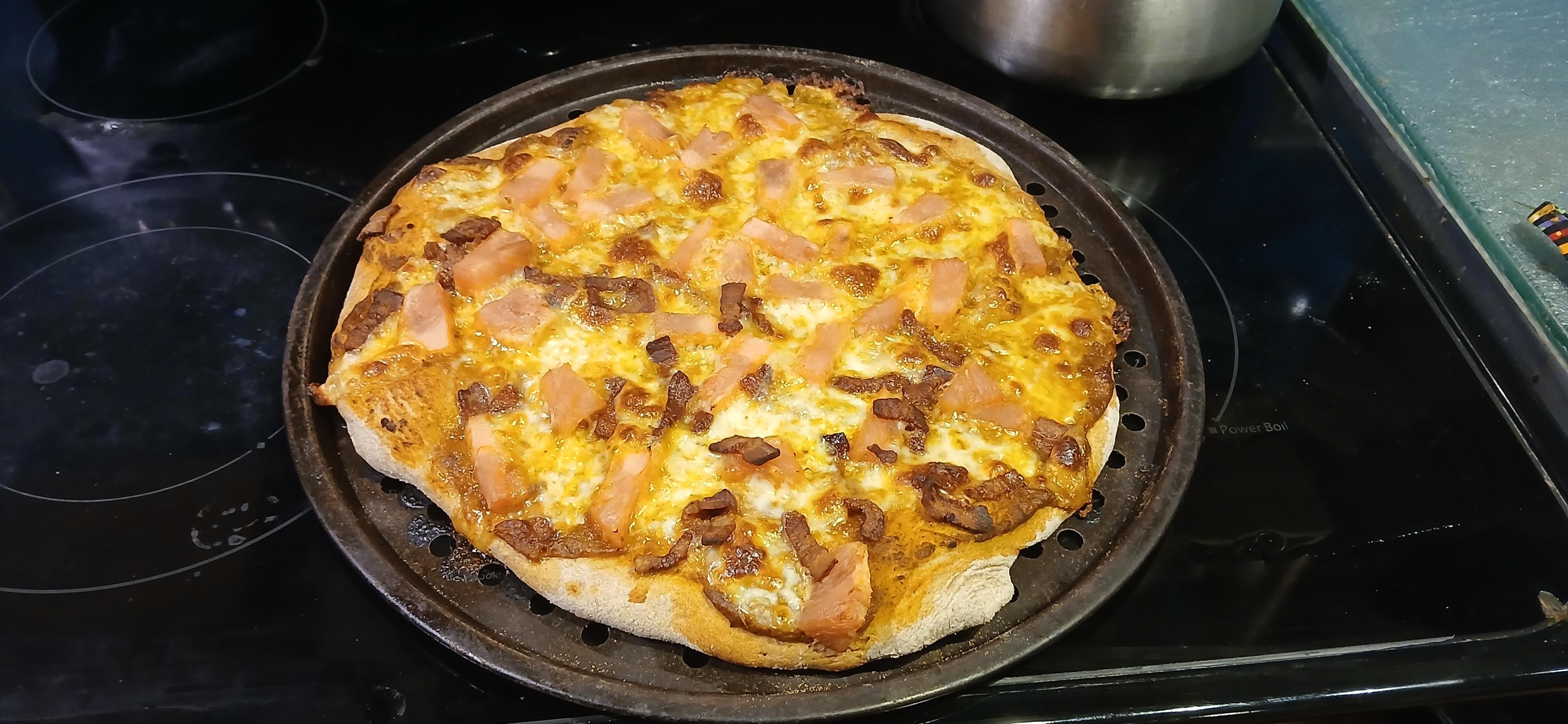 Cooked pineapple pizza on the oven top