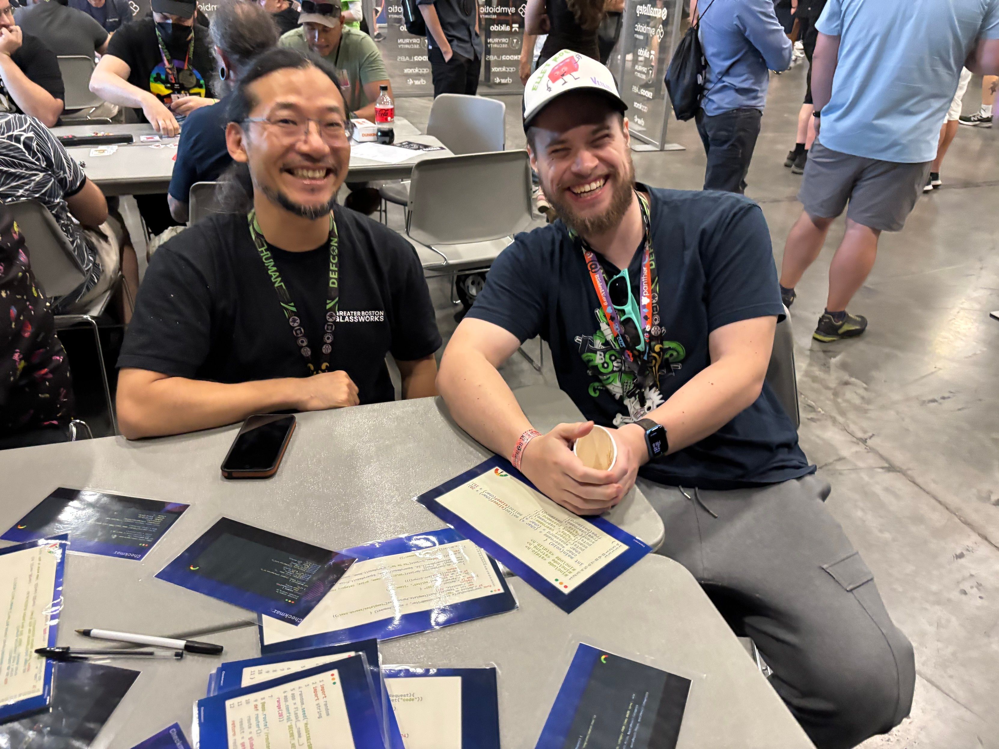 Two defcon attendees at the vulnerability hunt pod table