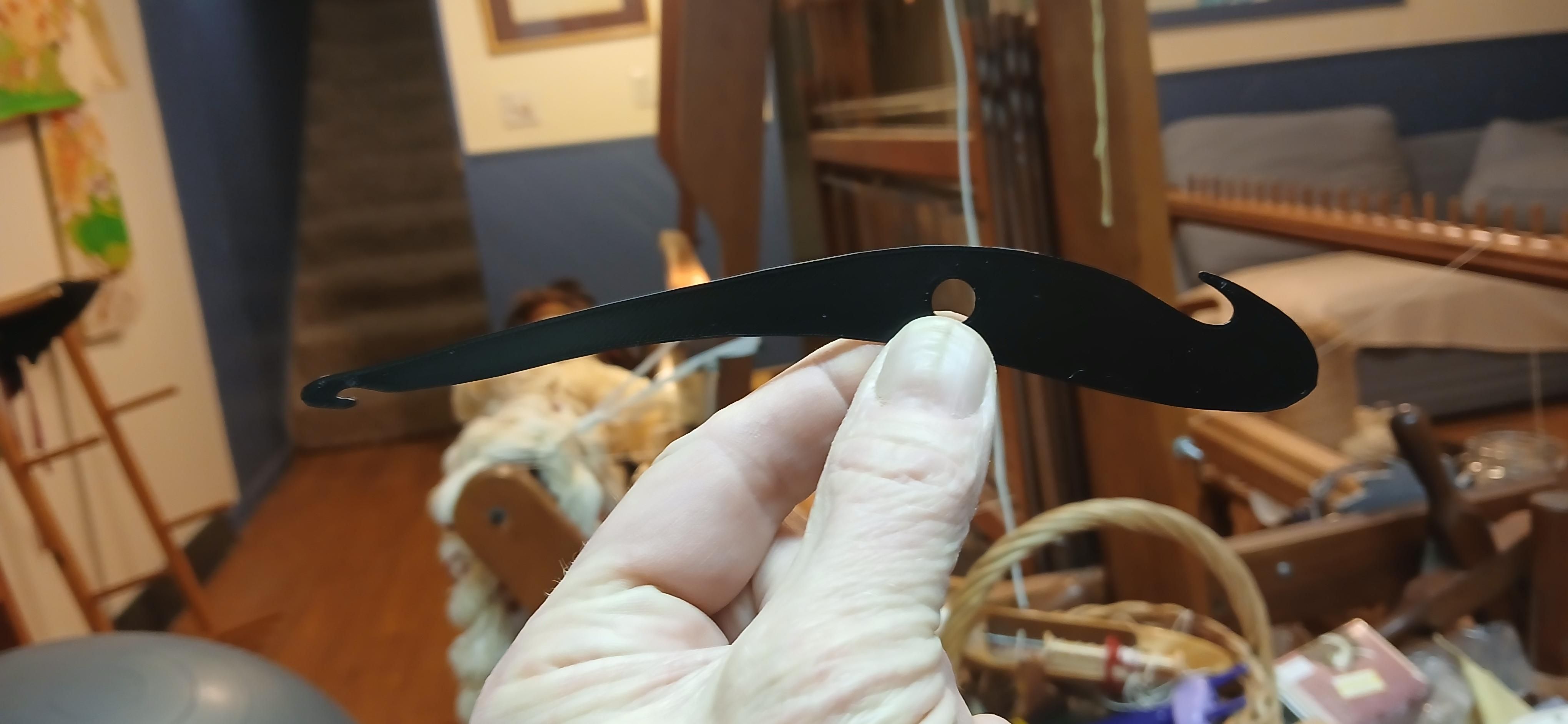 Black hook in front of floor rug loom