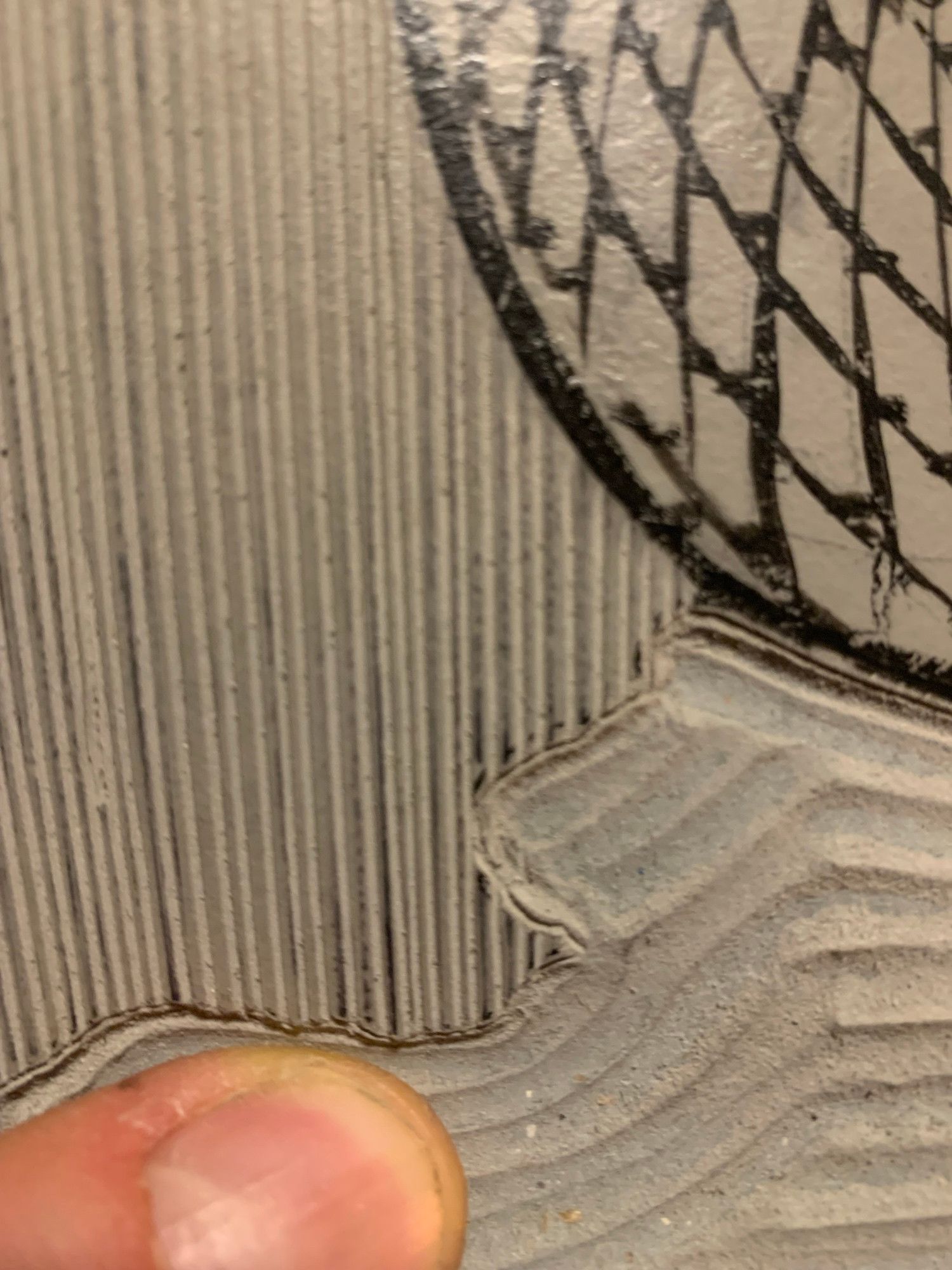 Vue de près d’un détail de gravure : plein de grands traits verticaux très fins espacés d’un millimètre 