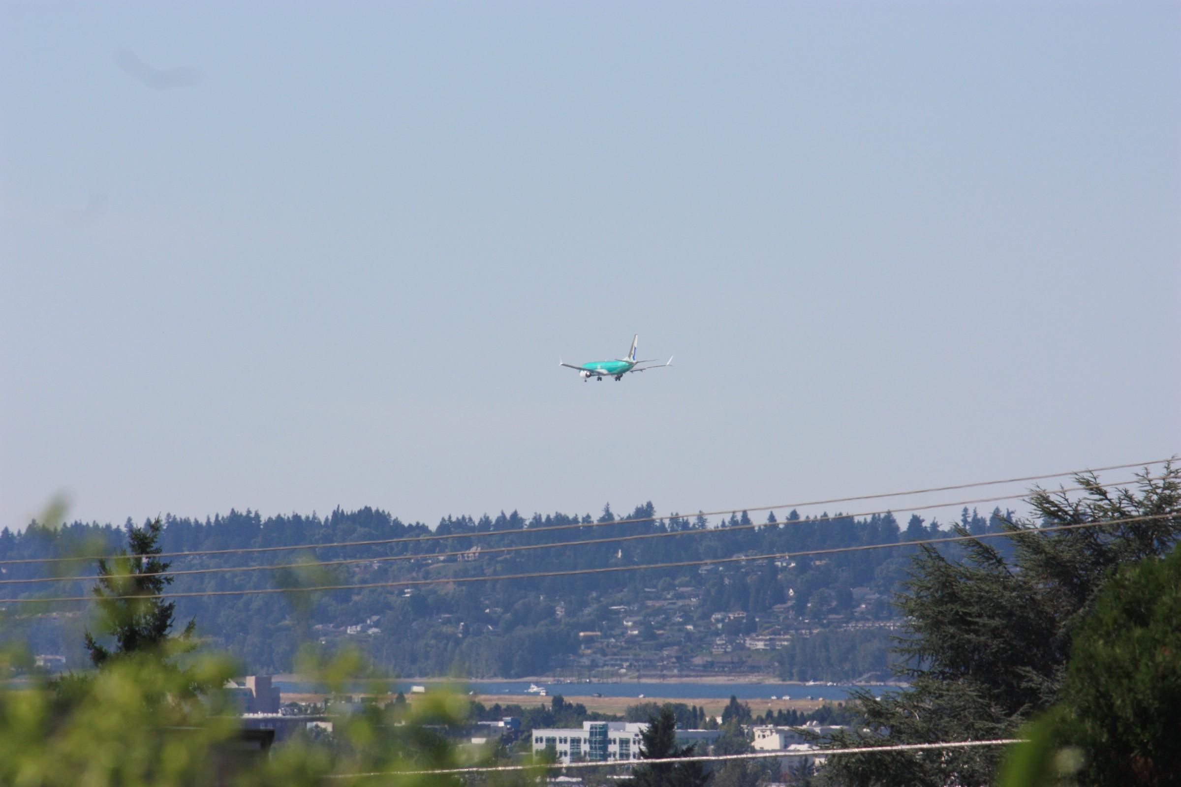 A brand new green unpainted Boeing 737 MAX8 on final approach to Portland Int'l Airport PDX for painting. It flew in from the Boeing 737 factory in Renton, Washington, probably on this plane's first flight. The pre-painted rudder indicates this aircraft will go to SCAT Airlines of Kazakhstan.
In the background is the Portland Airport, Columbia River (Oregon/Washington border) and a tree-lined ridge in Vancouver, Washington.
photo by Ian Kluft
July 28, 2025
Portland, Oregon, USA