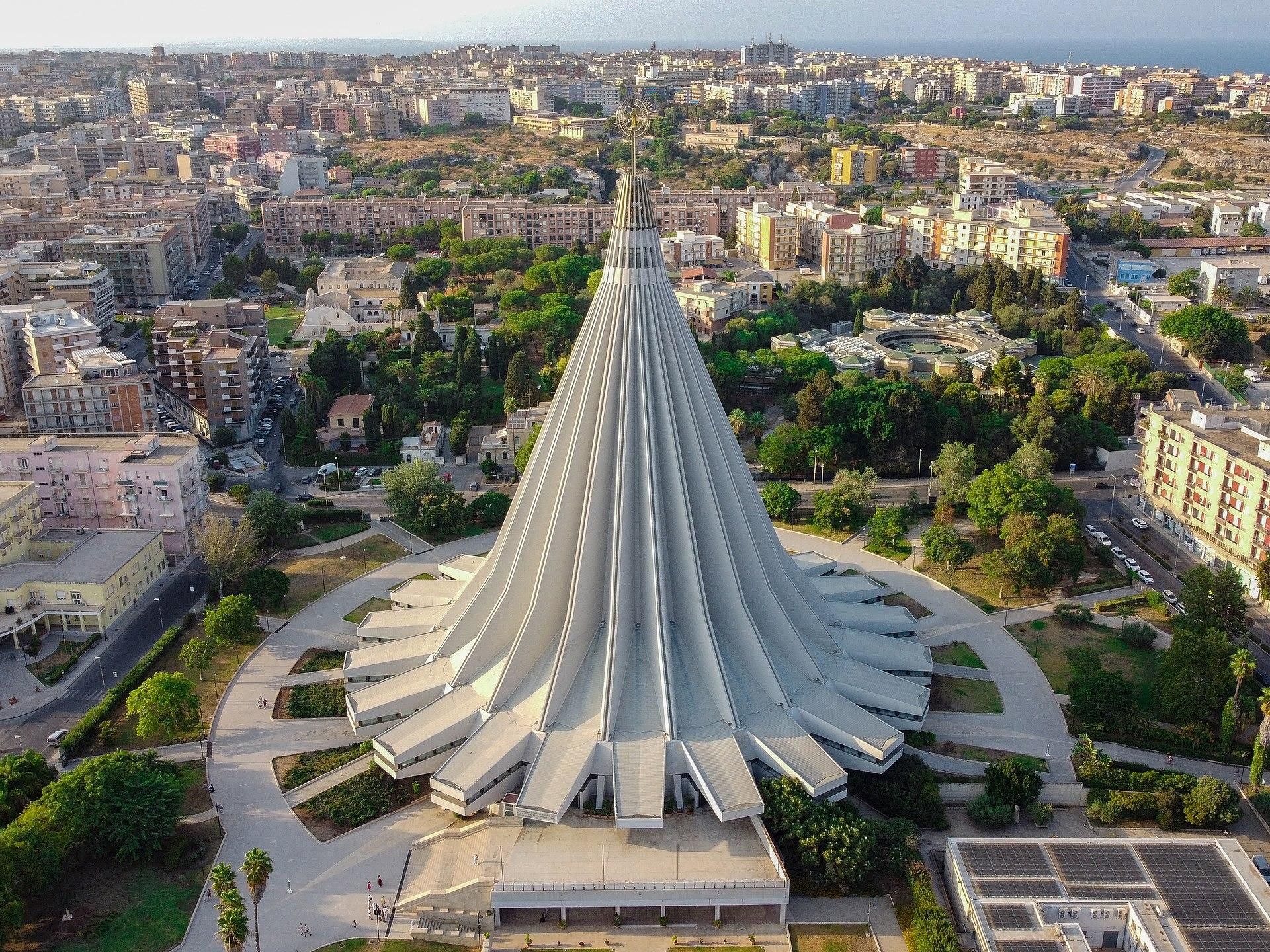 Un enorme spremiagrumi di cemento con intorno una città