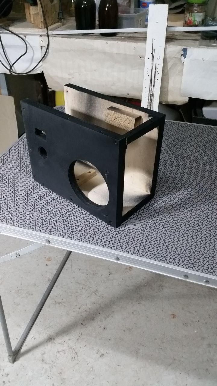 Contenitore in compensato di recupero per l'alimentatore ATX di recupero, verniciato a spray nero.
Su un fianco un foro per la ventola, per la presa accendisigari e il voltmetro.