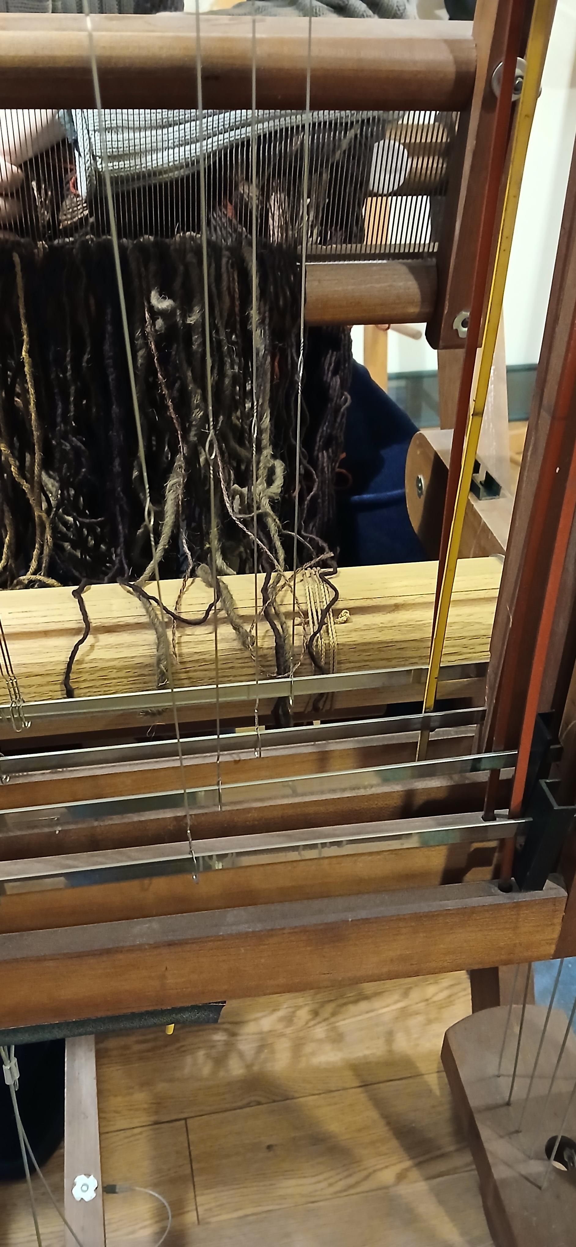 Wire heddles lined up on right. Sometimes it's best to start in the center if it's a narrow weave but this is full width.