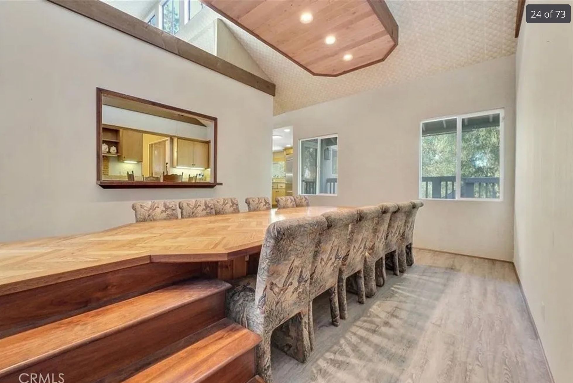 A very long dining table that also might double as a fashion runway because on one side of the table there are stairs built into it. 