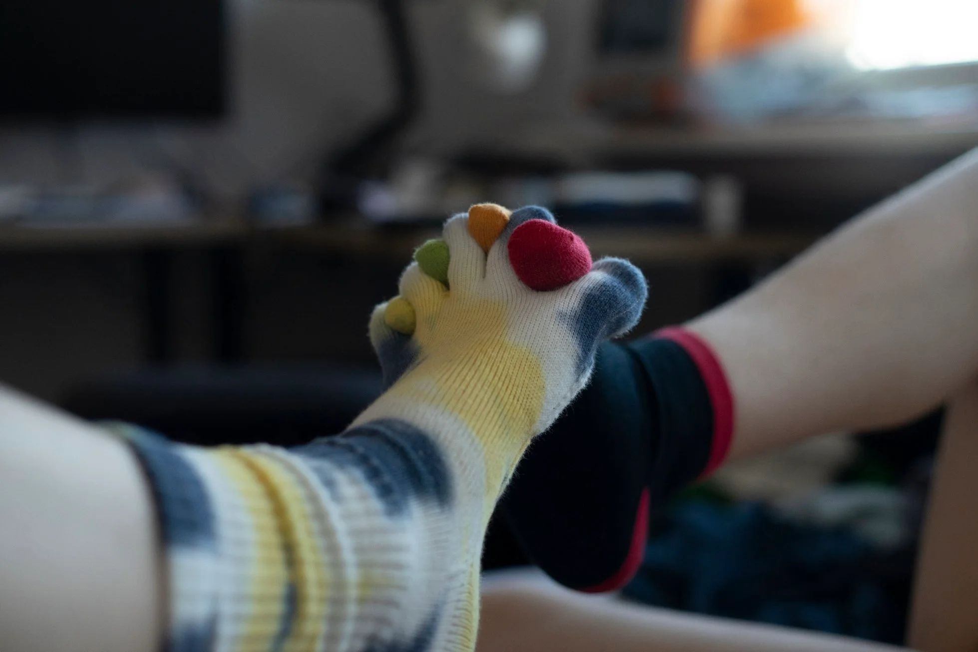 two feet in toe socks holding one another