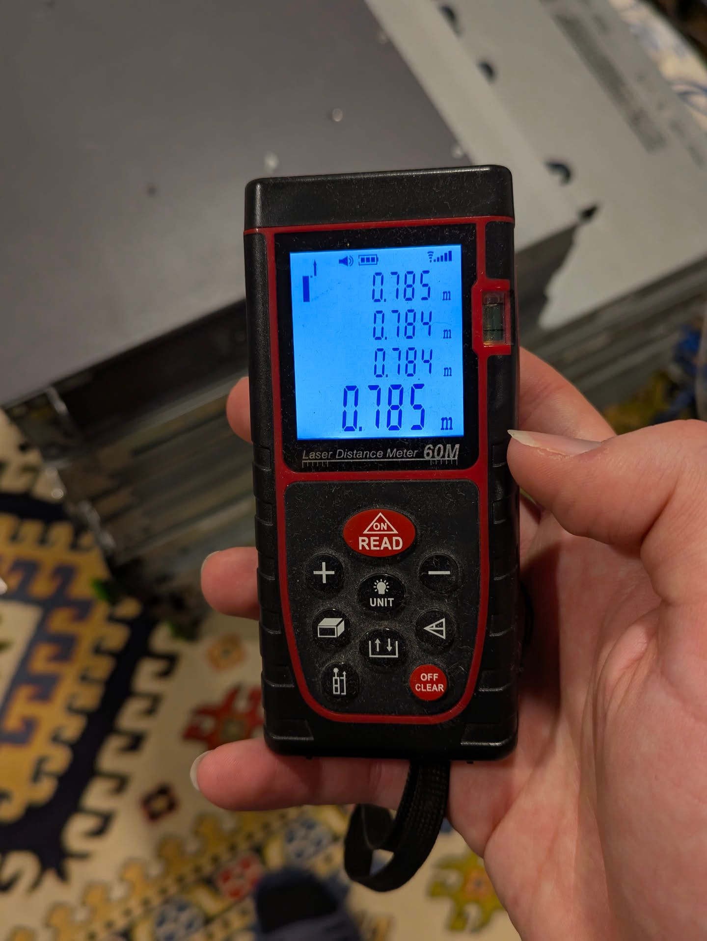 a laser rangefinder showing measurements of the stack height (4 measurements):
- 0.785m
- 0.784m
- 0.784m
- 0.785m