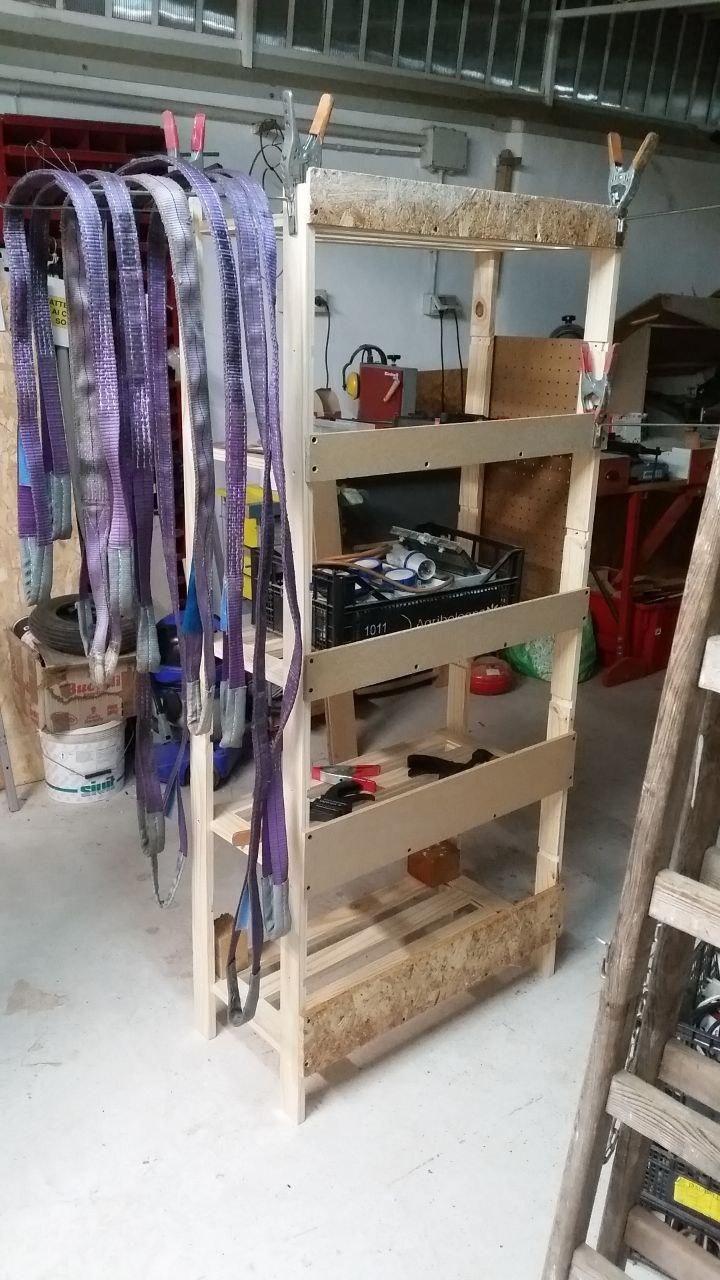 Scaffale in legno con cinghie di sollevamento viola appese sul lato sinistro.