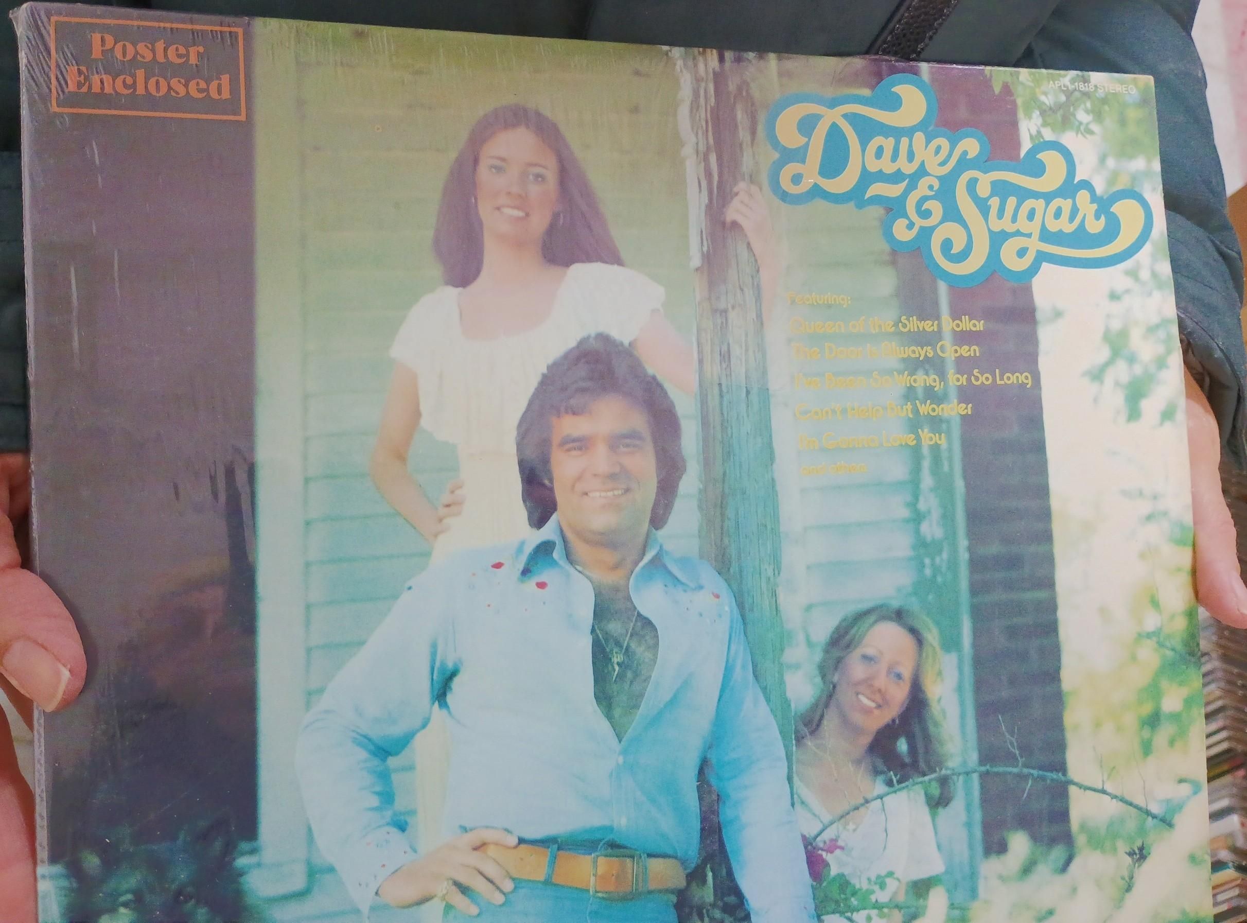 A funny 1970s album cover for a group called "Dave and Sugar" inexplicably with three people who just warrant the handle Sugar. 

Dave has got his shirt open with an hilarious rug of a chest hair.