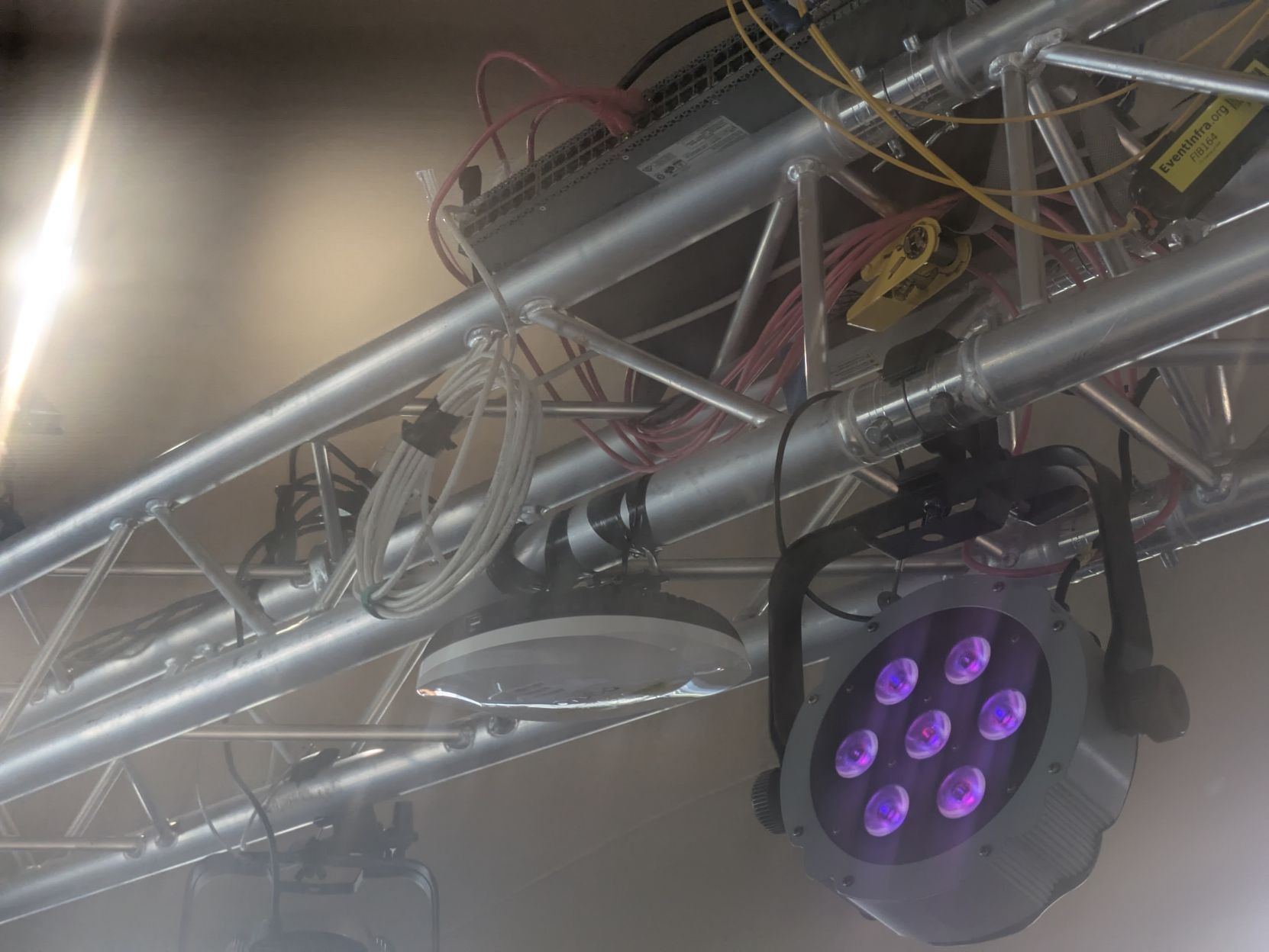 An Aruba access point hanging off of electrical tape wraps