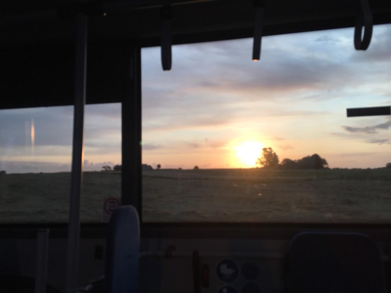 Sunrise seen through the window of a bus. 