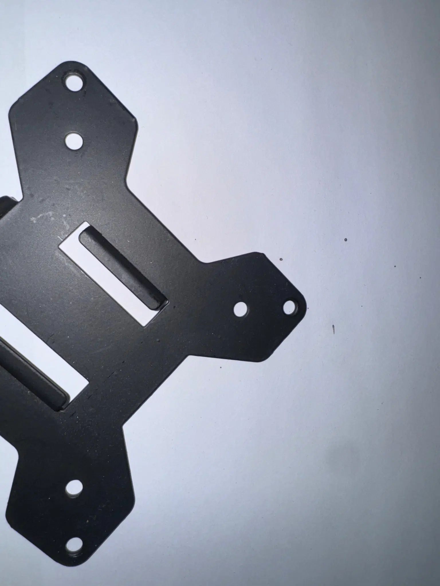 A mounting bracket with a square ish corner on a neck, and a pair of two holes 