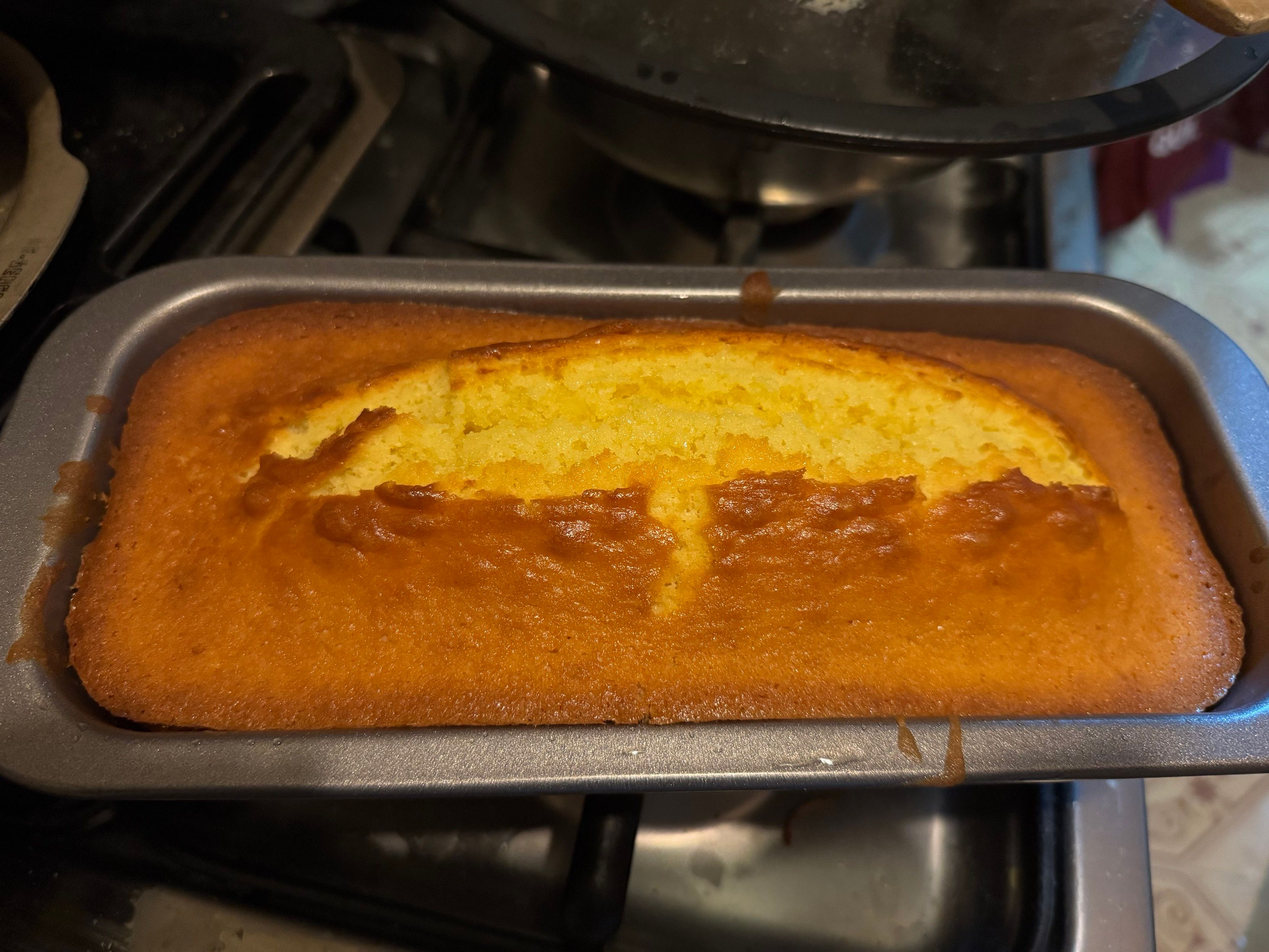 Foto di un plumcake fatto in casa, appena sfornato, all'interno del proprio stampo. 