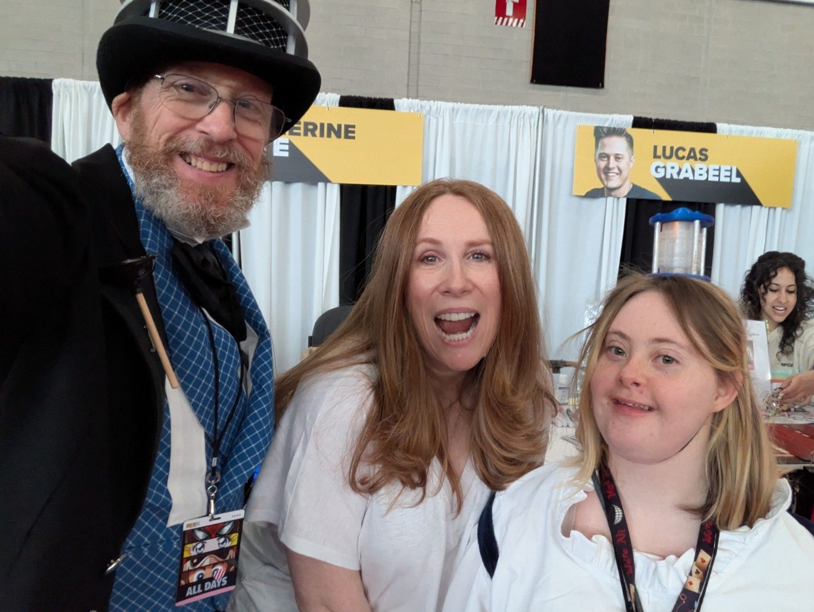 A man in 1850s formal wear altered to look a Dalek and a young woman with Down syndrome dressed up as a TARDIS flank Catherine Tate
